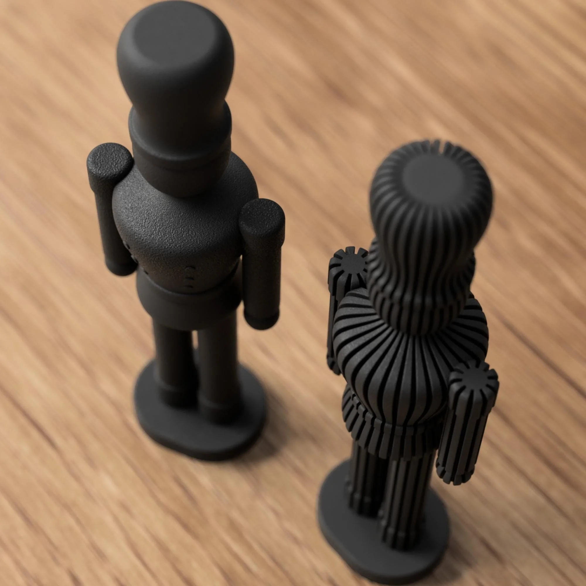Schwarzer Nussknacker und schwarze gerippte Variante schräg von oben, mit Fokus auf Form, Höhe und strukturierte Details.