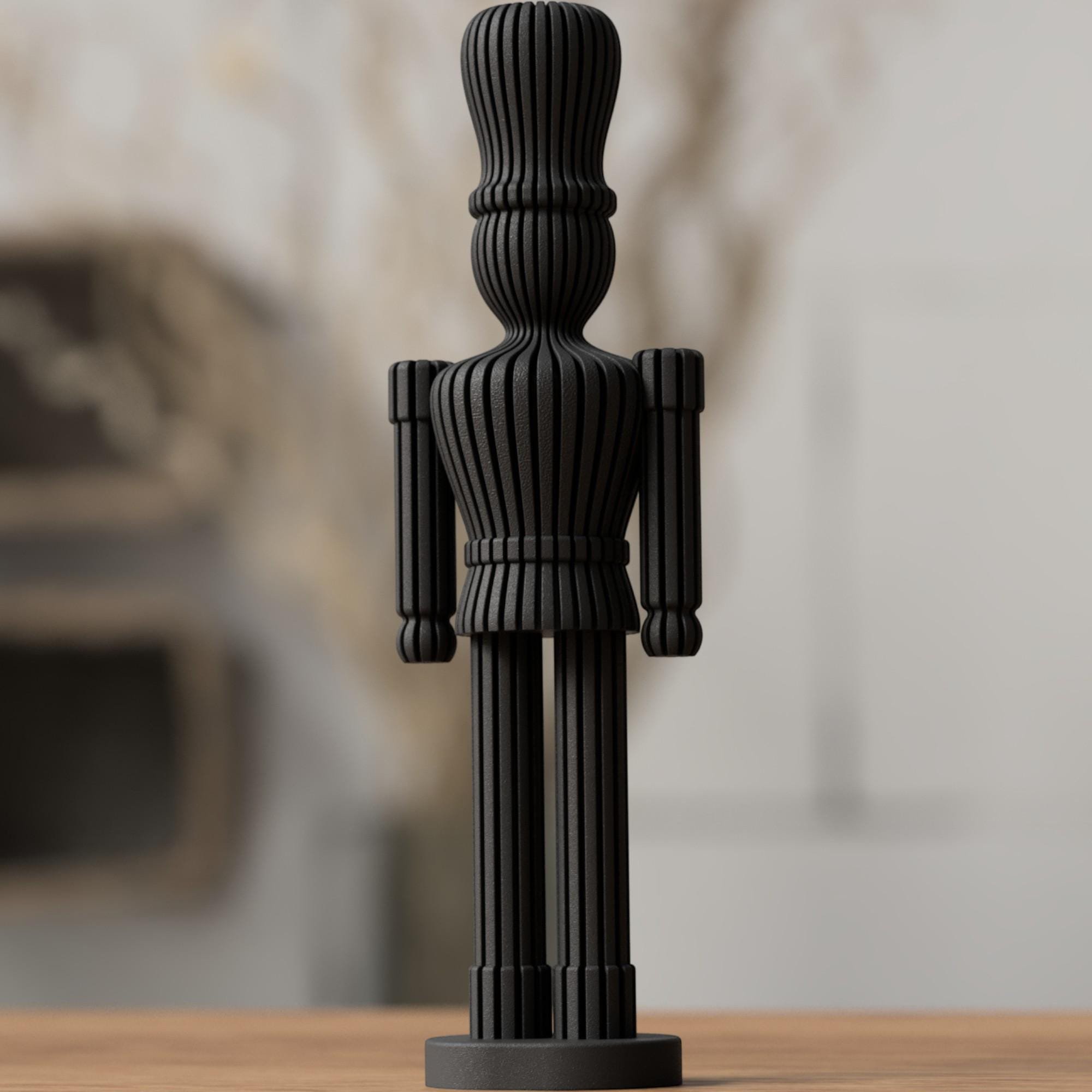 Schwarzer Nussknacker mit schlanker Silhouette und feinen Linien, frontal platziert als modernes Dekoobjekt für die Weihnachtszeit.