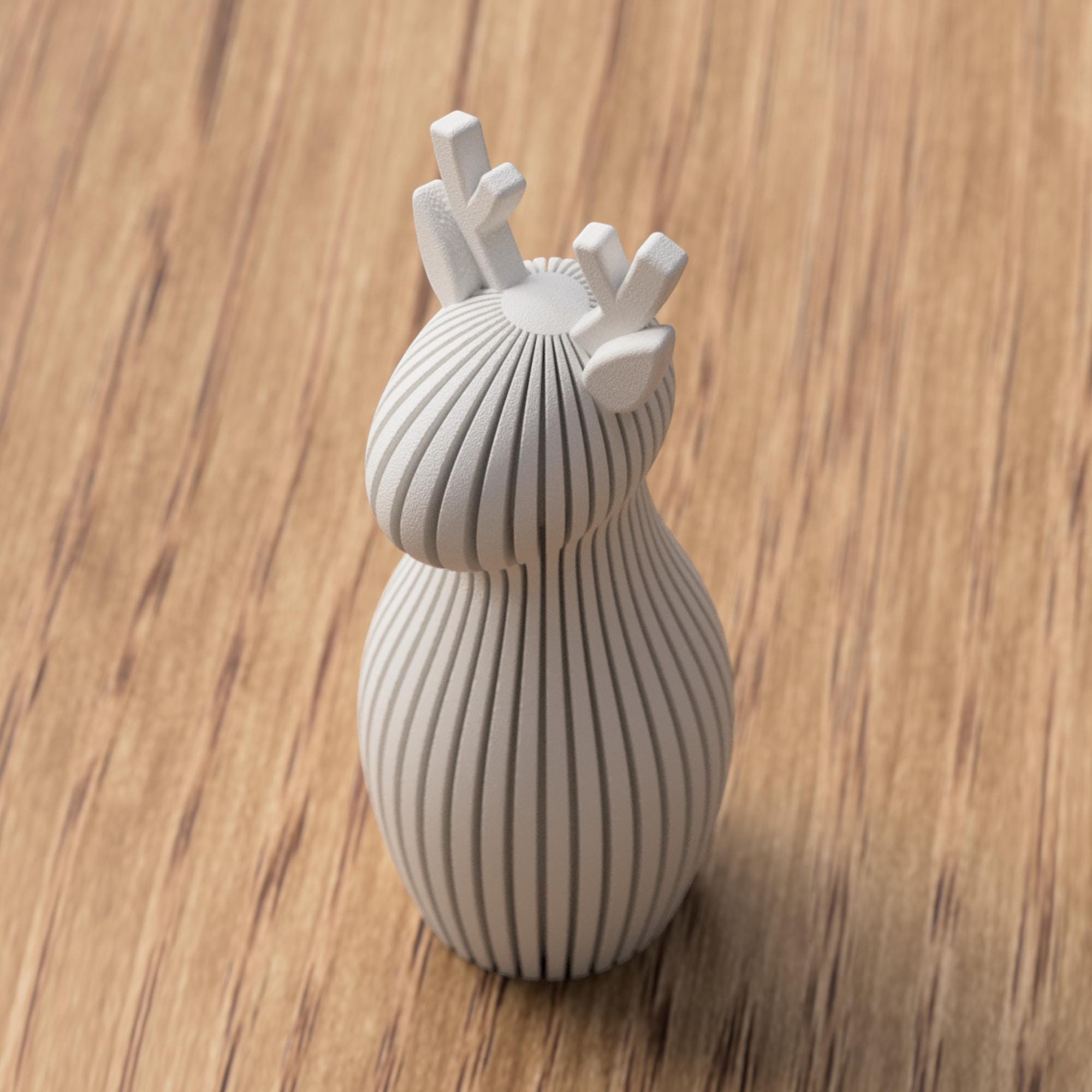 Weiße Rentier Figur mit vertikaler Rillenstruktur und dekorativem Geweih, einzeln auf Holz im reduzierten Stil präsentiert.