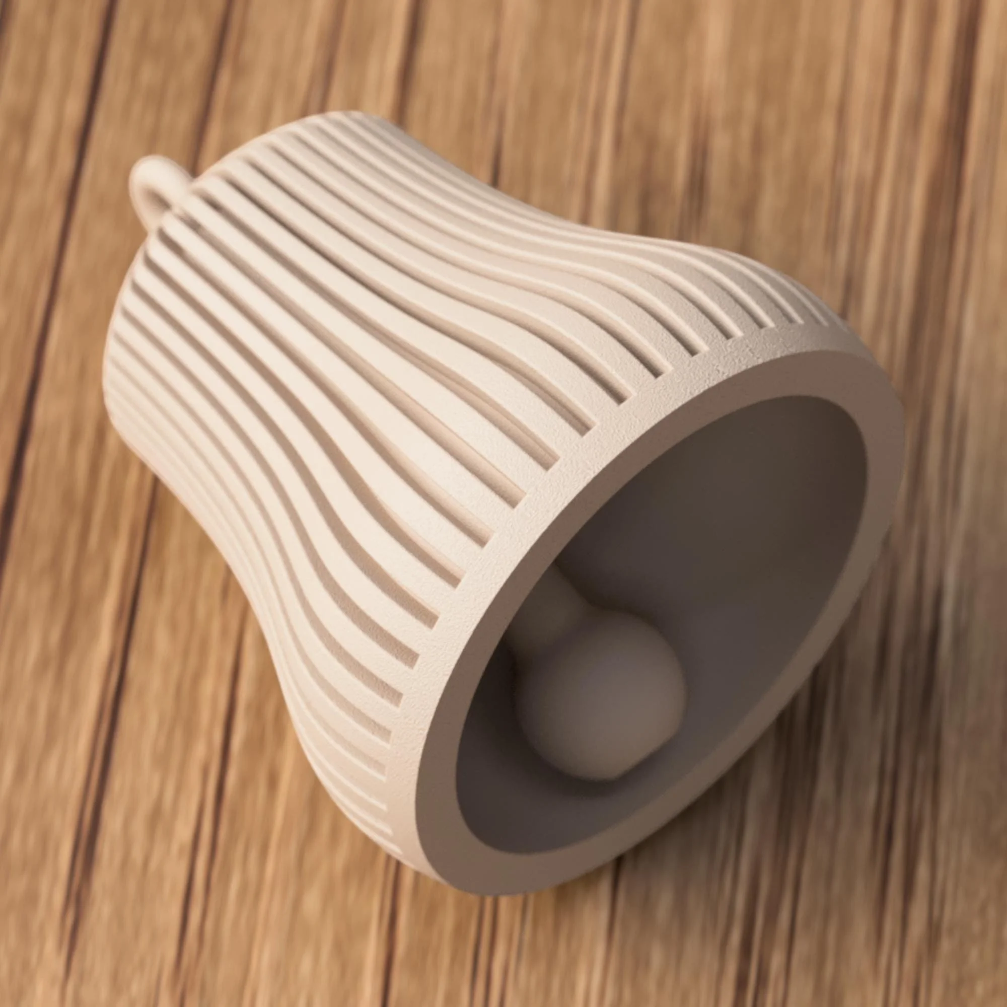 Beige Weihnachtsglocke liegend mit sichtbarer Öffnung und Klöppel, Fokus auf Form, Material und feine Oberflächenstruktur