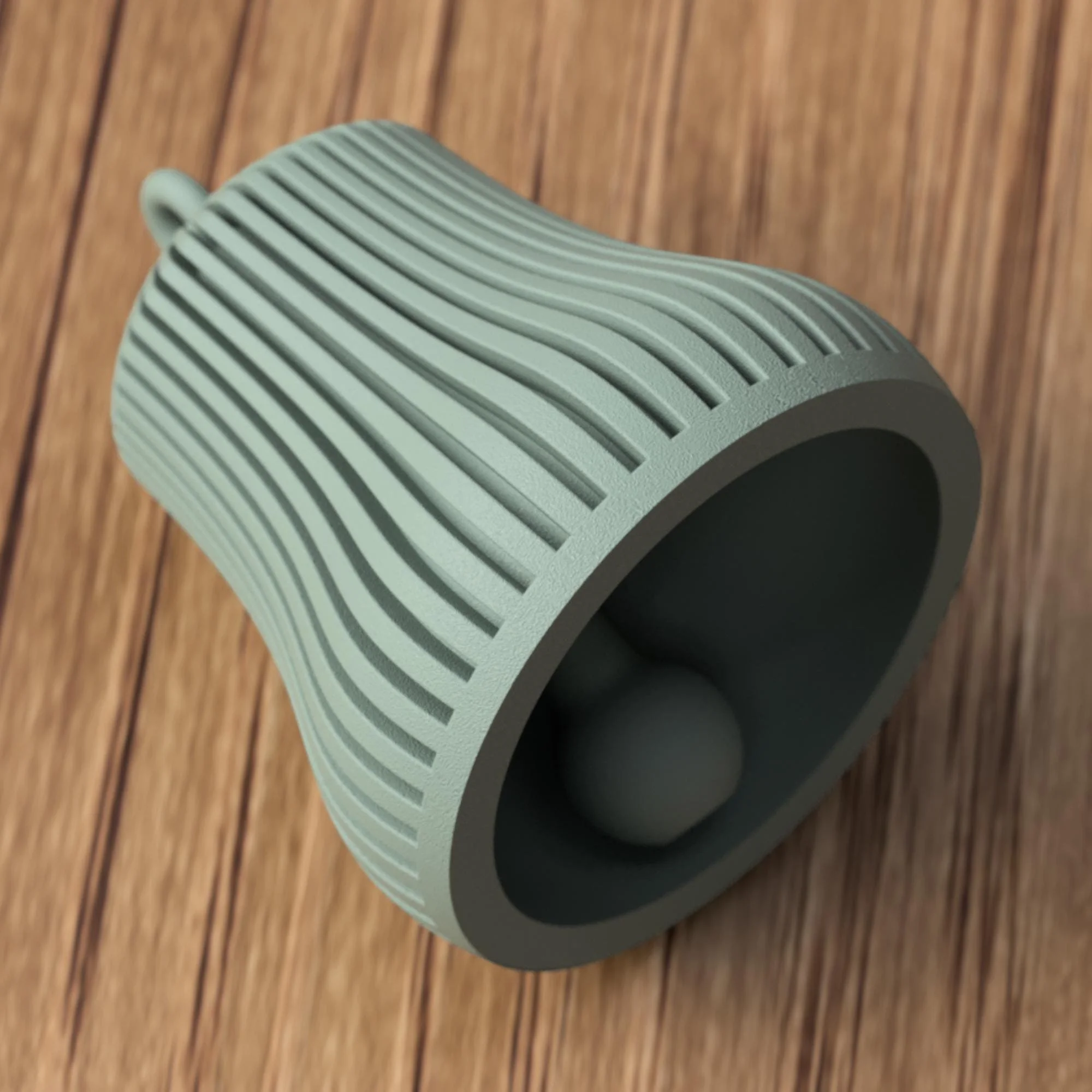 Grüne Glocke liegend mit sichtbarer Innenkammer und Klöppel, Fokus auf Material, Struktur und Verarbeitung im Detail