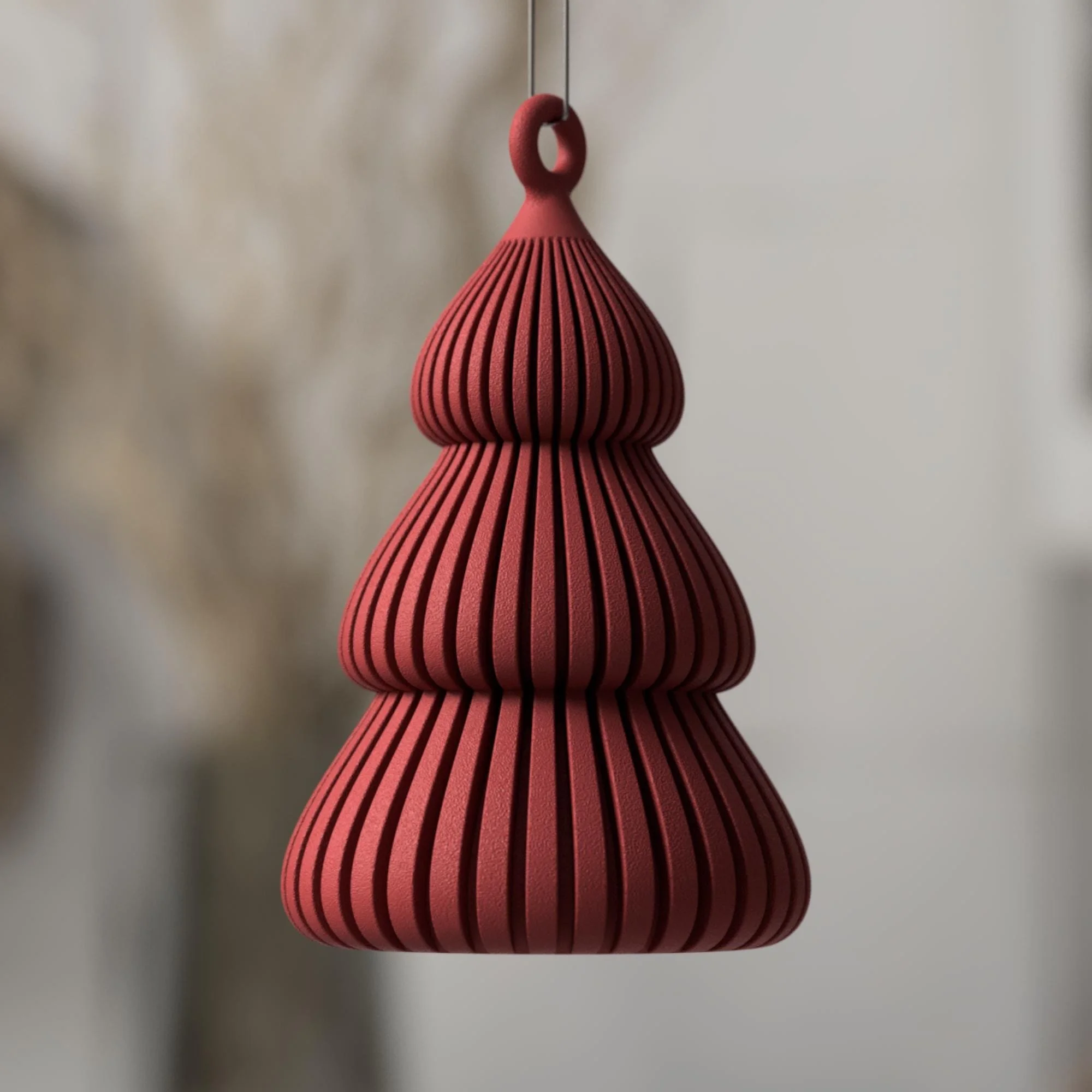 Roter Weihnachtsbaum Anhänger mit klarer Tannenform, gerippter Oberfläche und kleiner Öse als moderner Baumschmuck in minimalistischer Optik.