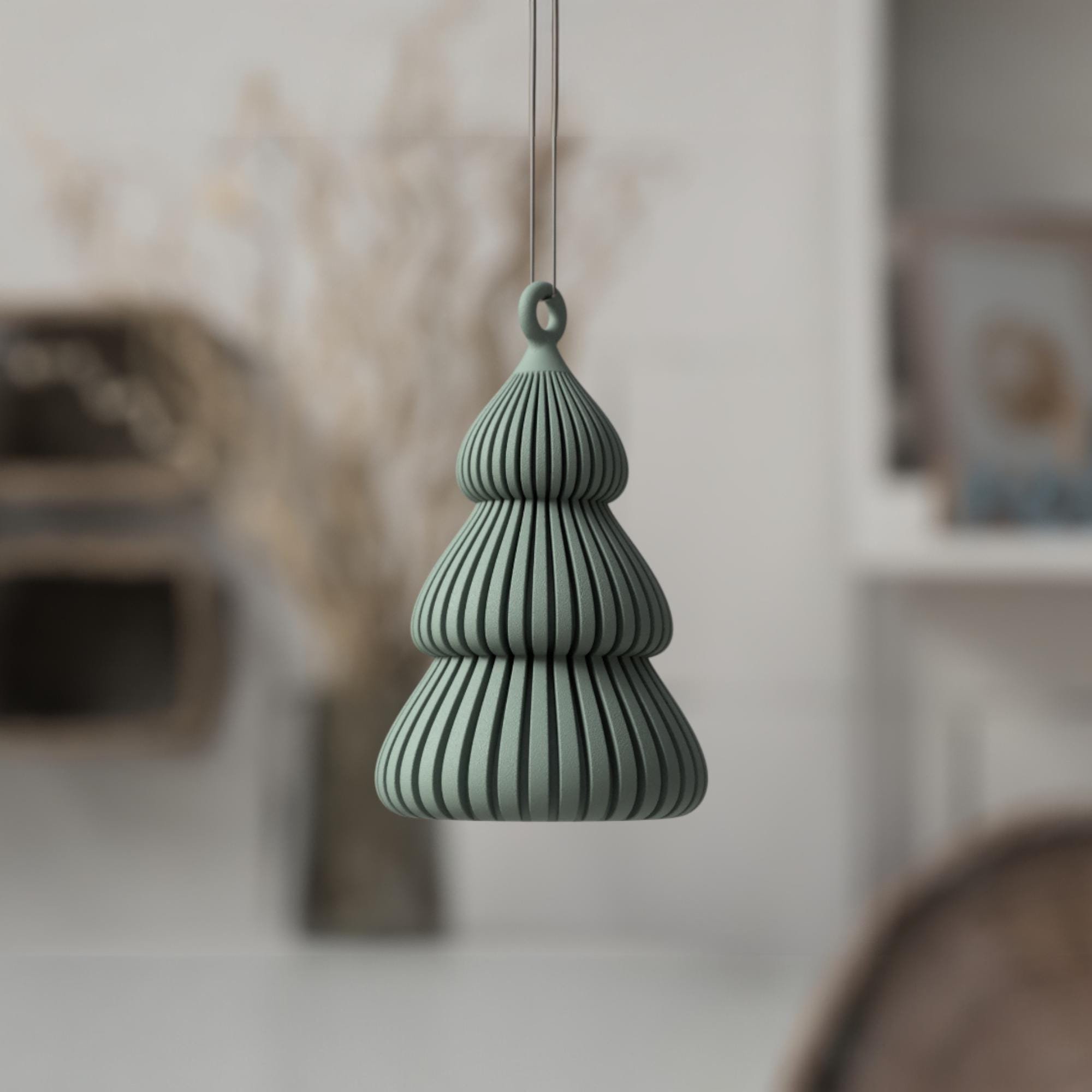 Salbeigrüner Weihnachtsbaum Anhänger an einem Zweig im Wohnraum, mit gerippter Tannenform als dezenter Akzent für moderne Festtagsdeko.