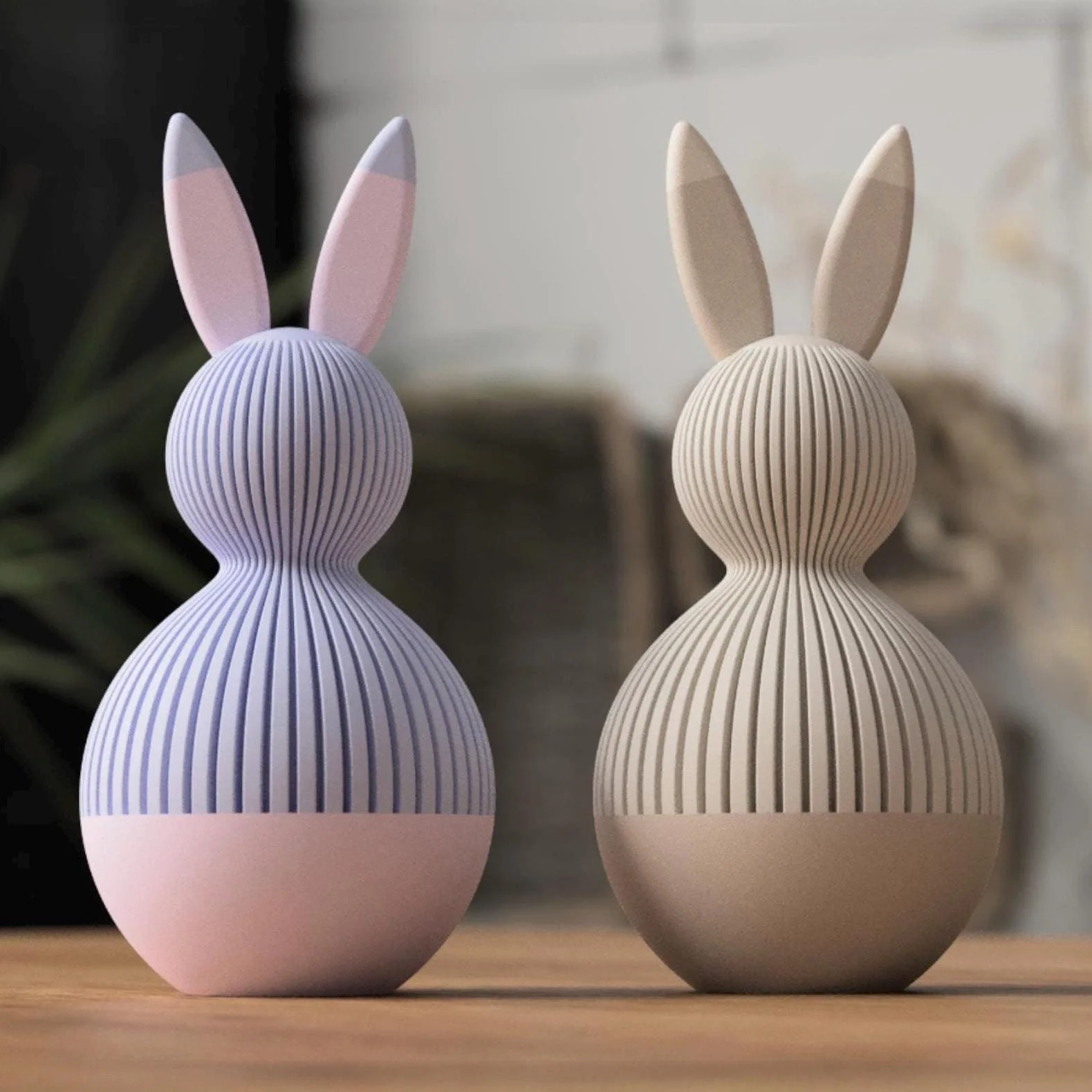 Zweifarbige Osterhasen im Japandi Stil in Lavendel und Beige mit feiner Rillenstruktur als moderne Osterdeko auf einem Holztisch.