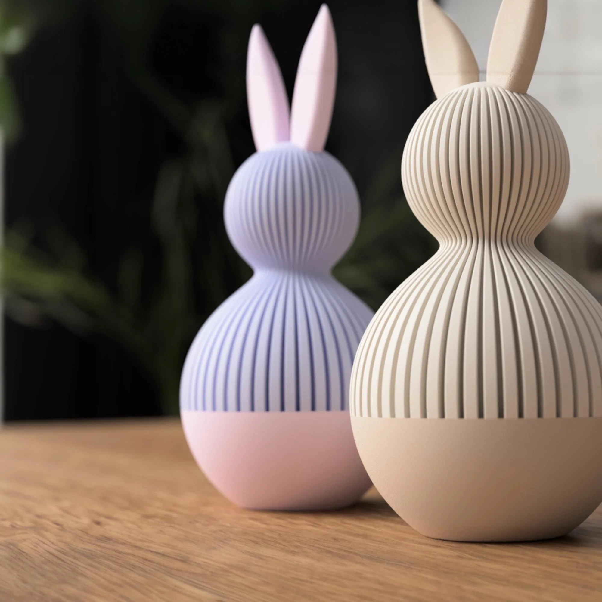Zwei Osterhasen im Japandi Stil seitlich arrangiert in Lavendel und Beige, mit langen Ohren und ruhiger Rillenstruktur auf einem Holztisch.