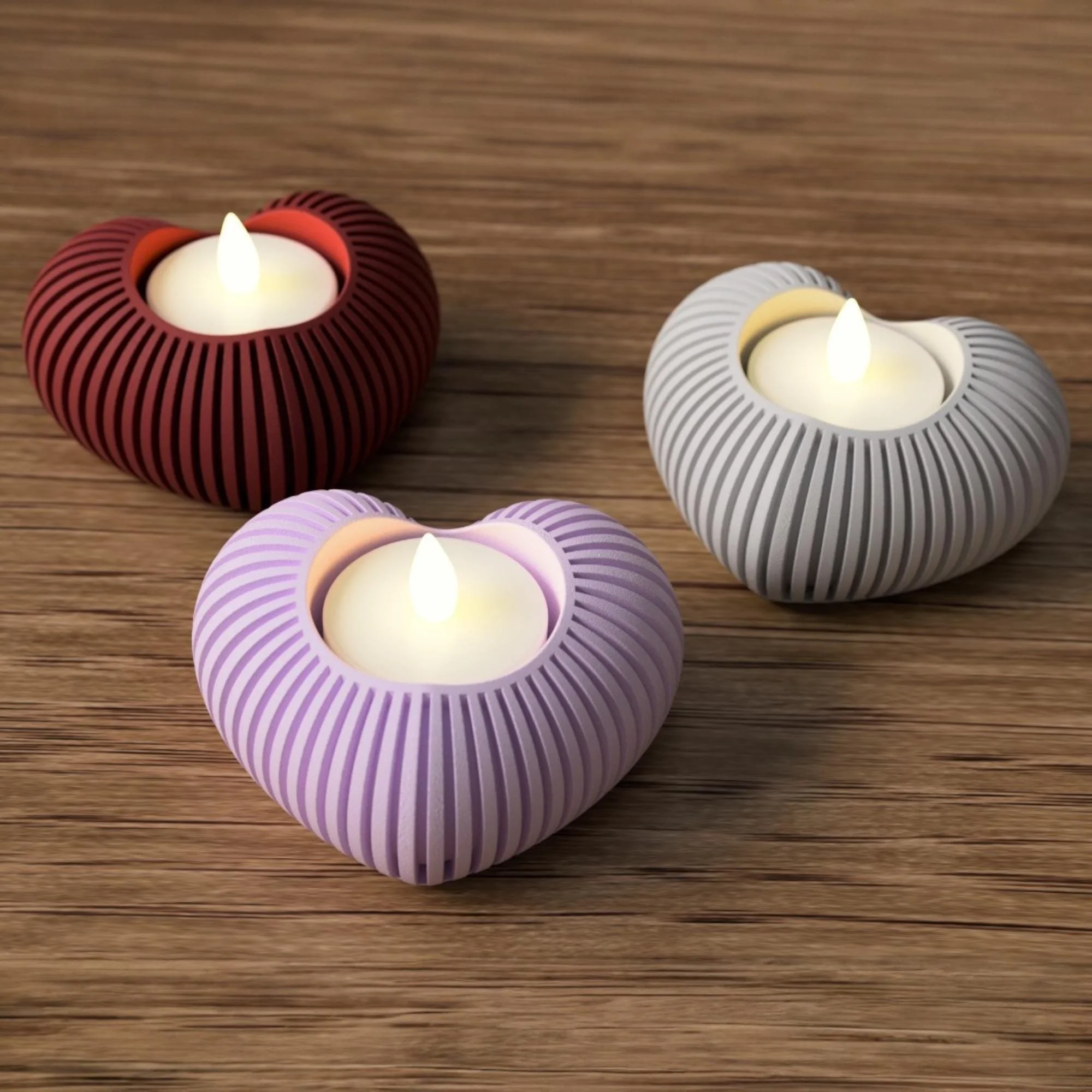 Herz-Teelichthalter im 3er-Set mit LED-Lichtern in Bordeauxrot, Pastellrosa und Weiß, dekorativ arrangiert auf einer Holzoberfläche.