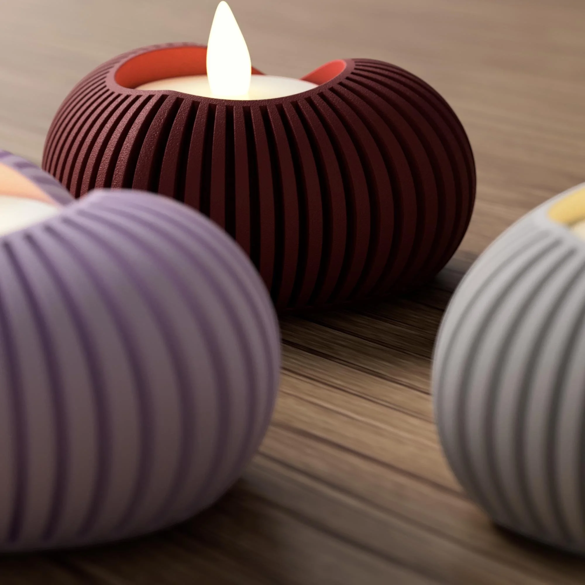 Bordeauxroter Herz-Teelichthalter mit LED-Licht in schräger Nahaufnahme, ergänzt durch unscharfe Elemente in Pastellrosa und Weiß im Vordergrund.