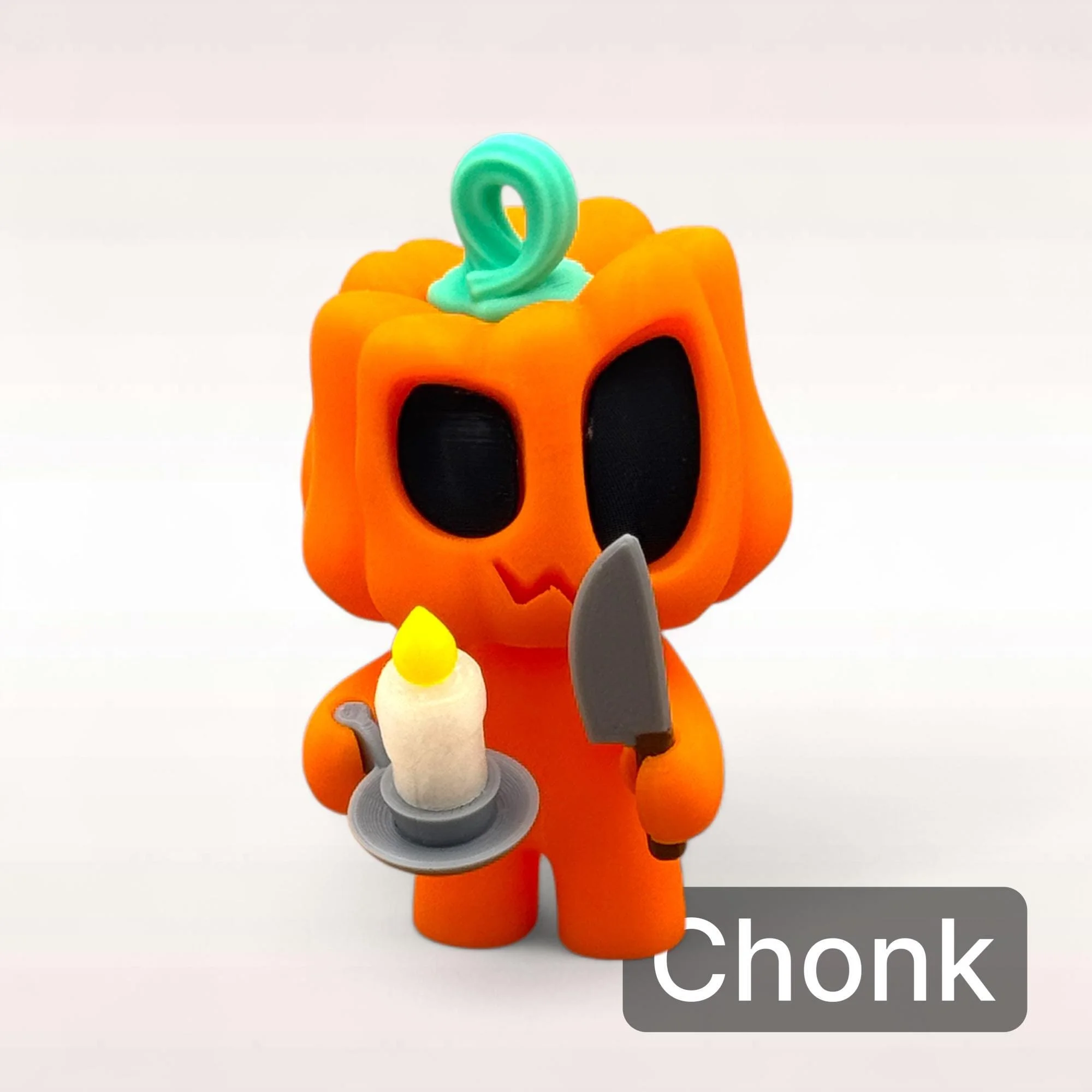 Mini Kürbis Figur Chonk in Orange mit rundlicher Form, schwarzen Augen und kleinem Zubehör als verspielte Halloween Deko.