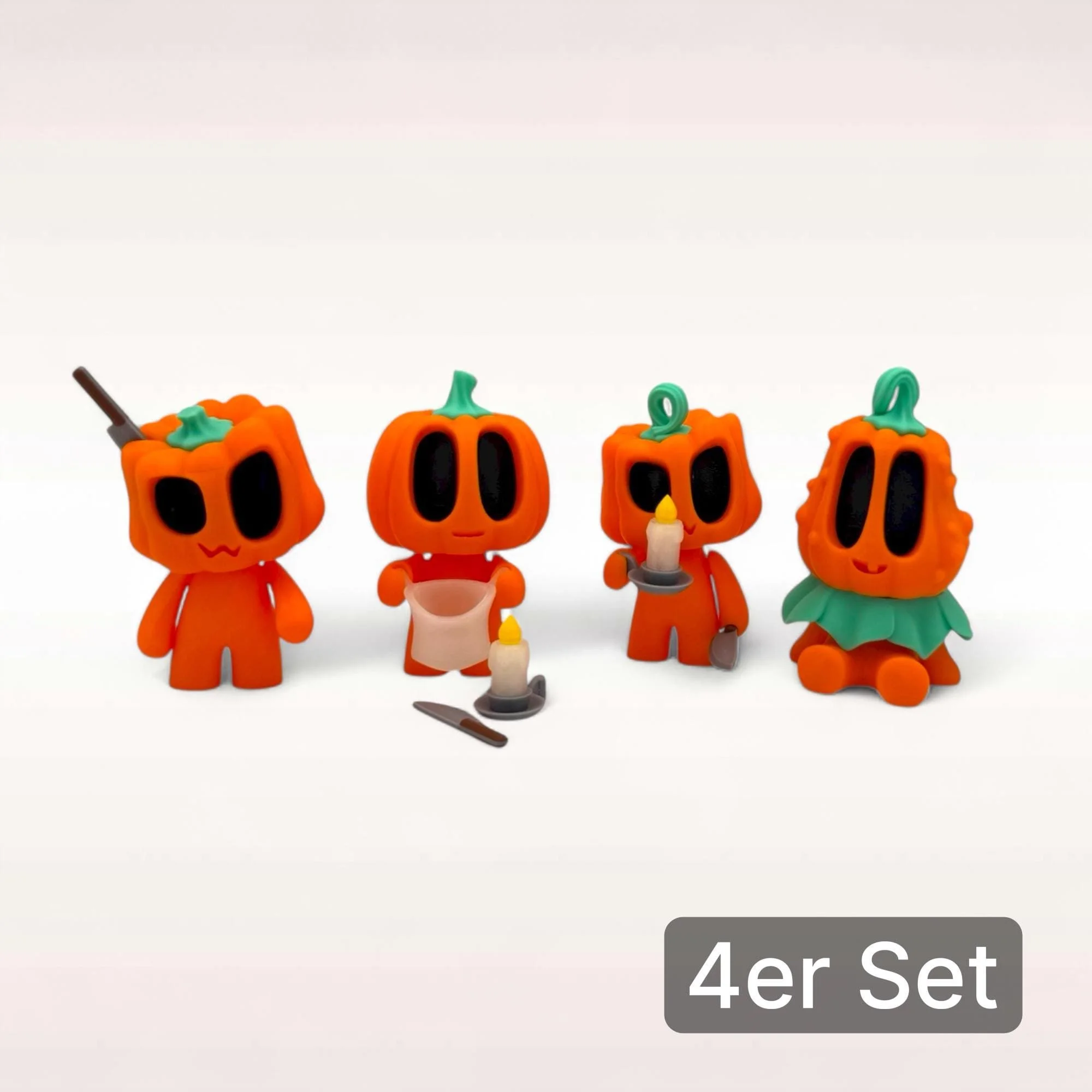 4er Set mit allen vier Mini Kürbis Figuren und kleinem Zubehör als vollständiges Halloween Deko Ensemble auf hellem Hintergrund.