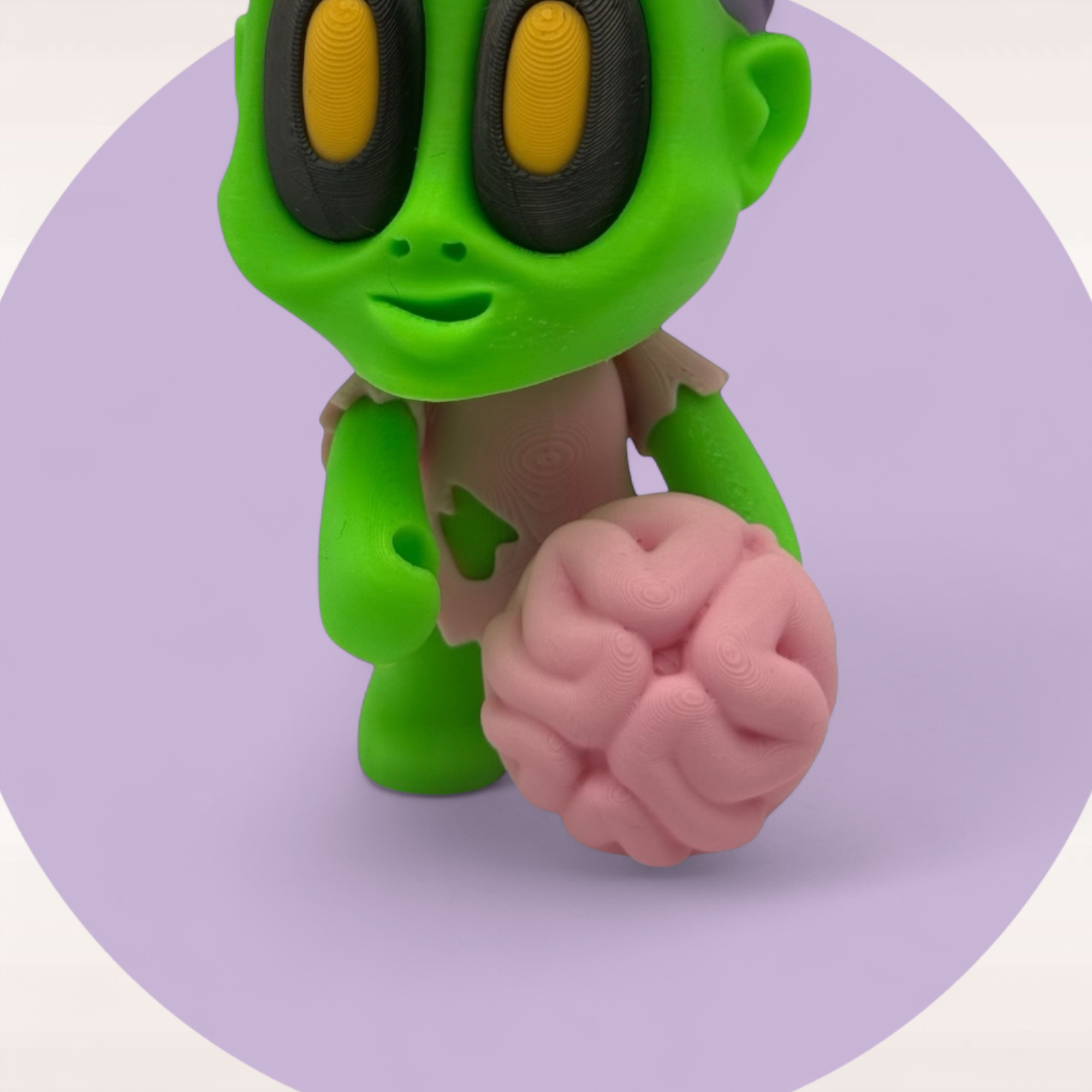 Detailbild der stehenden Figur mit pinkem Gehirn in der Hand, grünem Körper und großen Augen auf hellem Kreis.