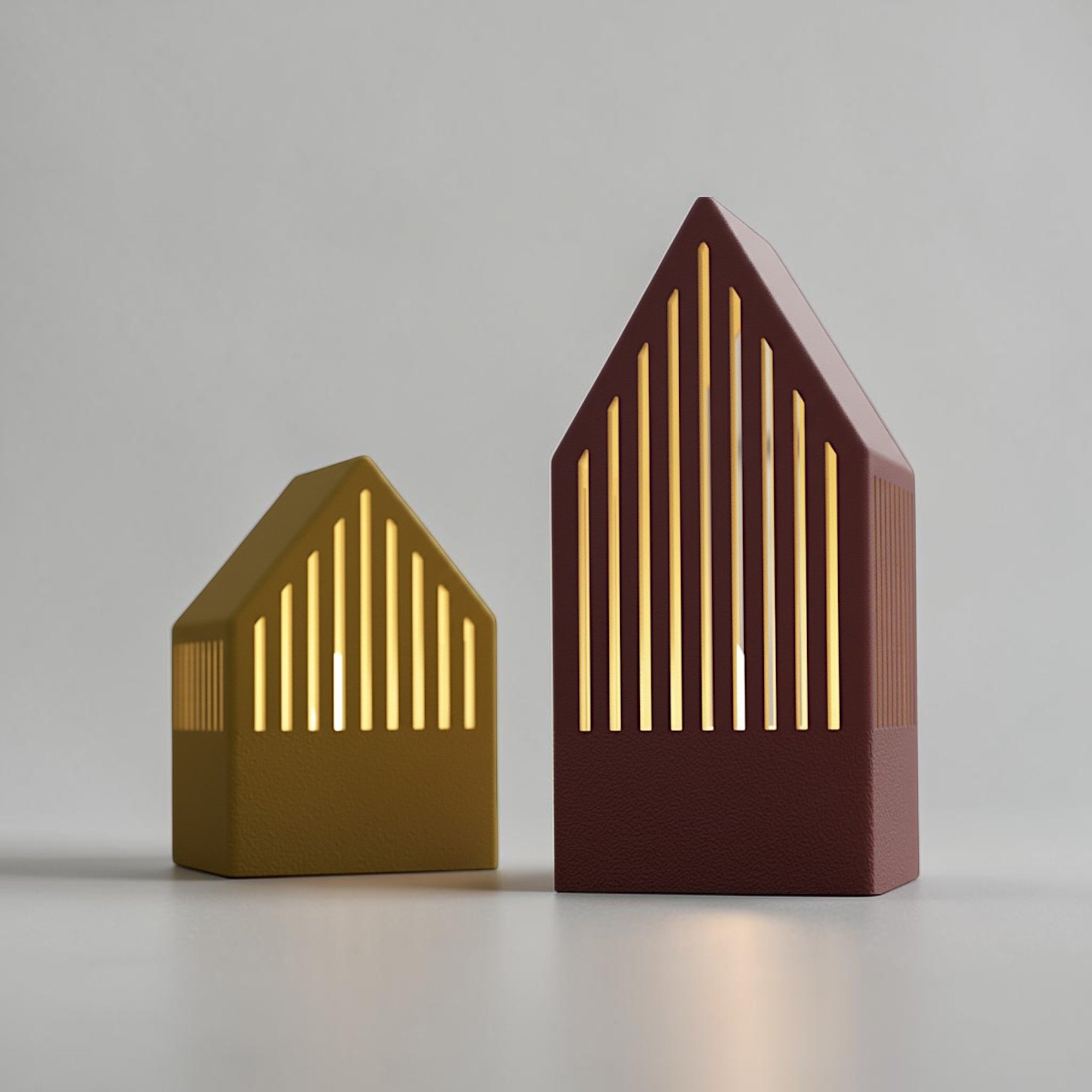 Japandi Teelichthäuser im Set aus großem und kleinem Haus mit feinen Lichtschlitzen in Gold und Bordeaux auf hellem Hintergrund.