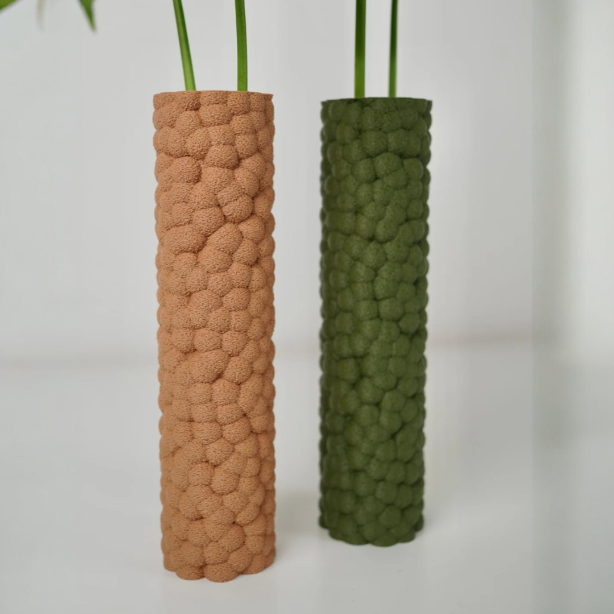 Brisa Dekovasen in Beige und Olivgrün mit skulpturaler Blasenstruktur, als schlankes Duo mit langen grünen Stielen dekoriert.