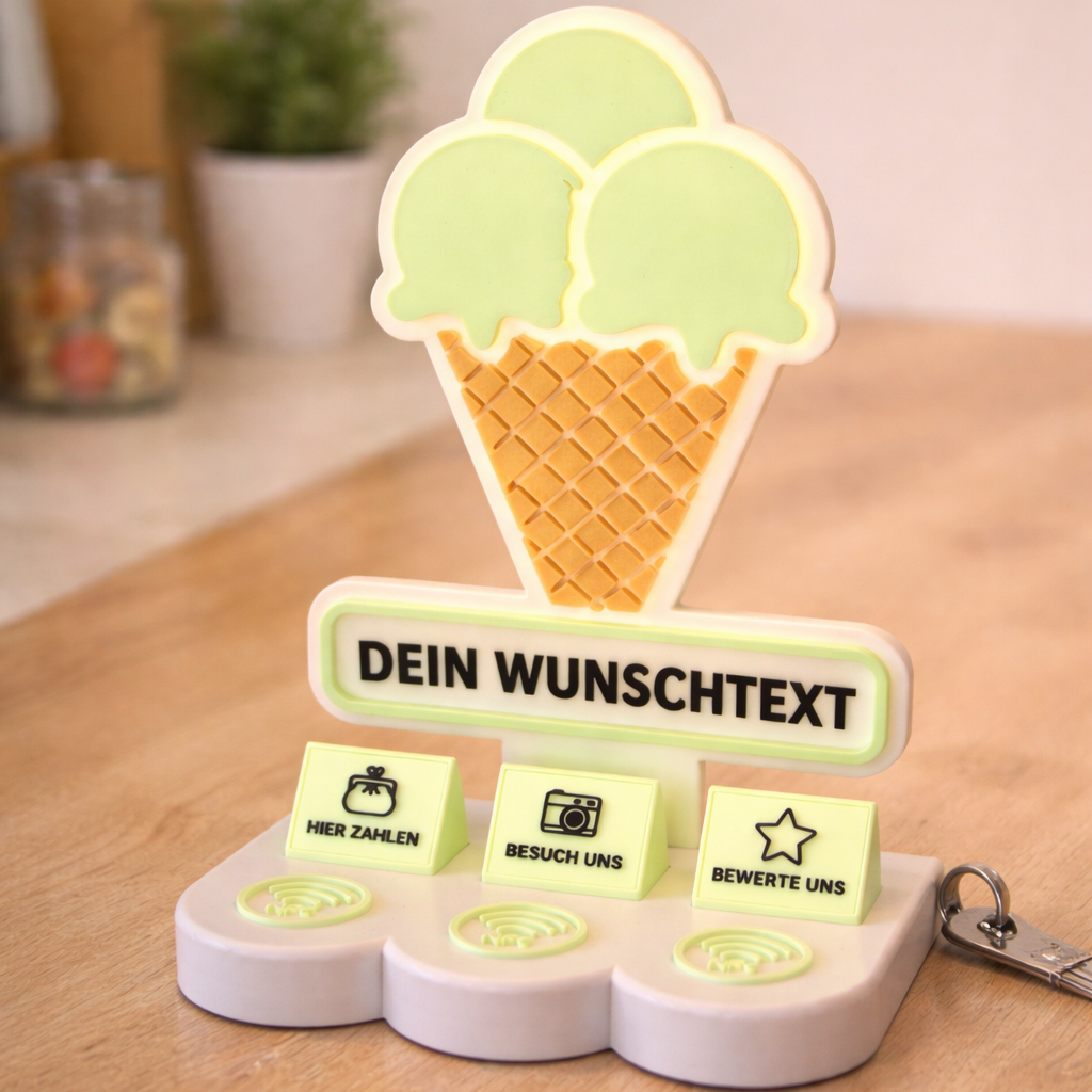 Personalisierter NFC Eistüten-Aufsteller mit Wunschtext und drei NFC-Flächen auf heller Fläche vor unscharfem Hintergrund.