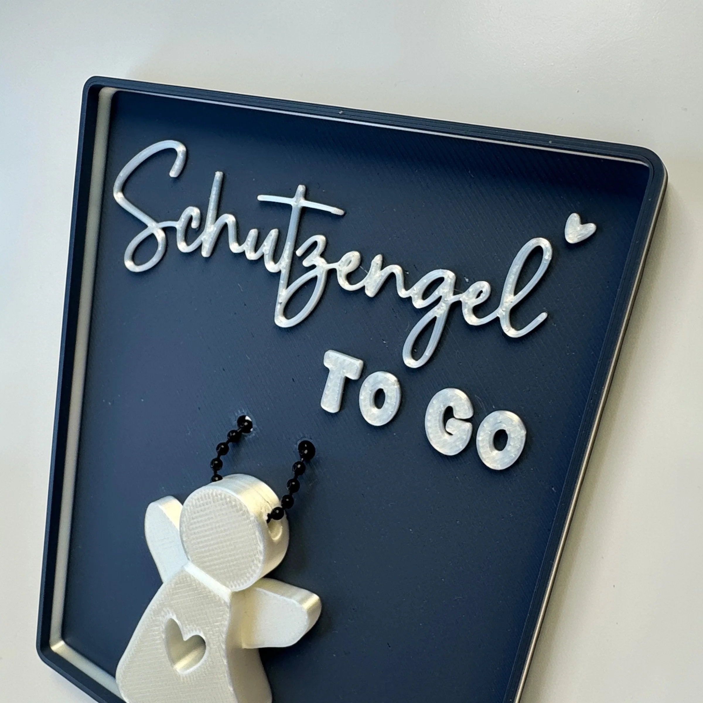 Nahaufnahme der blauen Spruchschale mit Schutzengel to go und weißem Engel Anhänger, betont den abnehmbaren Begleiter als kleines Geschenk.