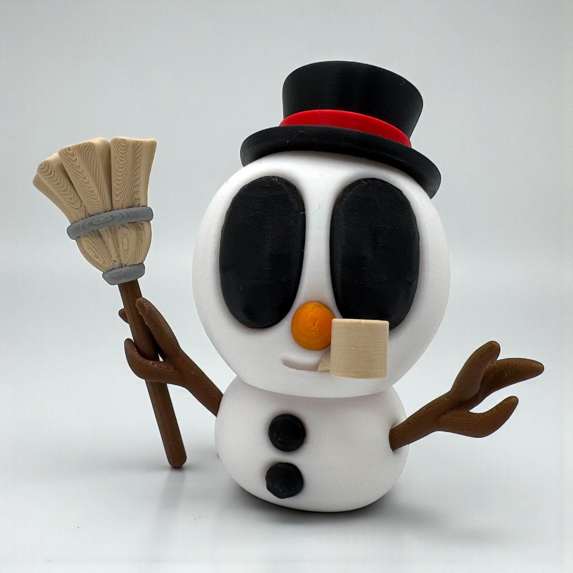 Schwarze Snowblobs Figur mit Zylinder, Besen und Pfeife auf hellem Hintergrund, als klassischer Schneemann mit markanten Details.