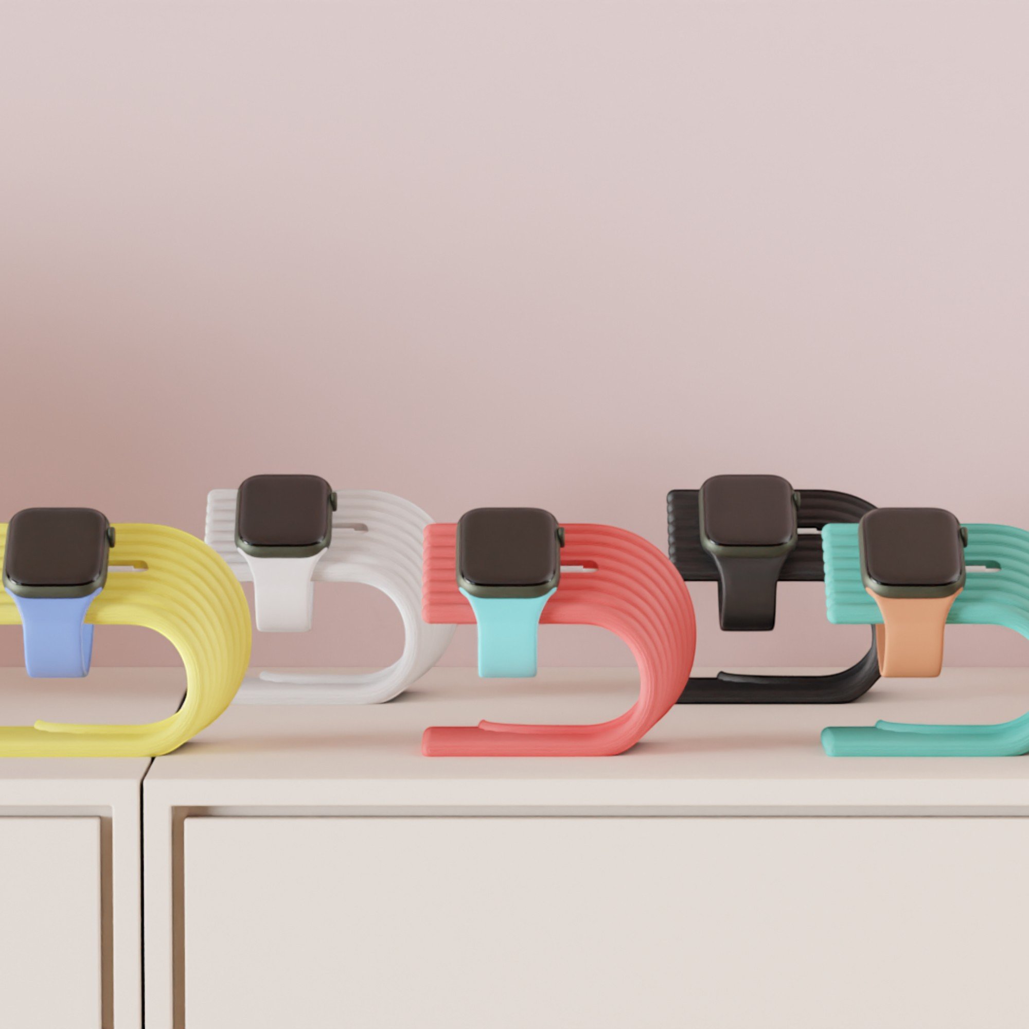 Apple Watch Ladeständer in mehreren Farben auf hellem Sideboard, farbige Auswahl für individuelle Kombinationen im modernen Wohnbereich.