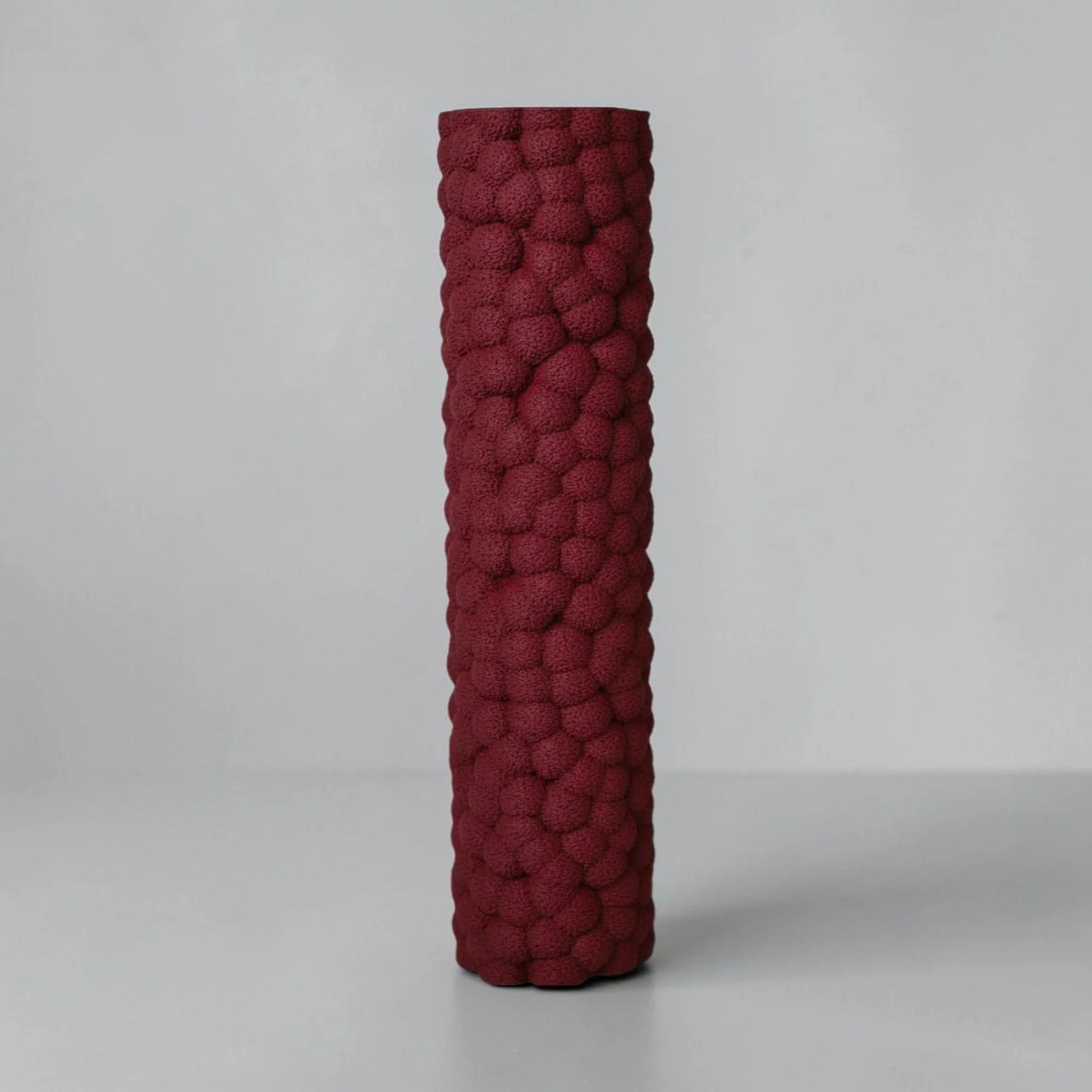 Schmale Brisa Dekovase in Bordeaux mit markanter blasenartiger Oberfläche als modernes Wohnaccessoire auf hellem Hintergrund.