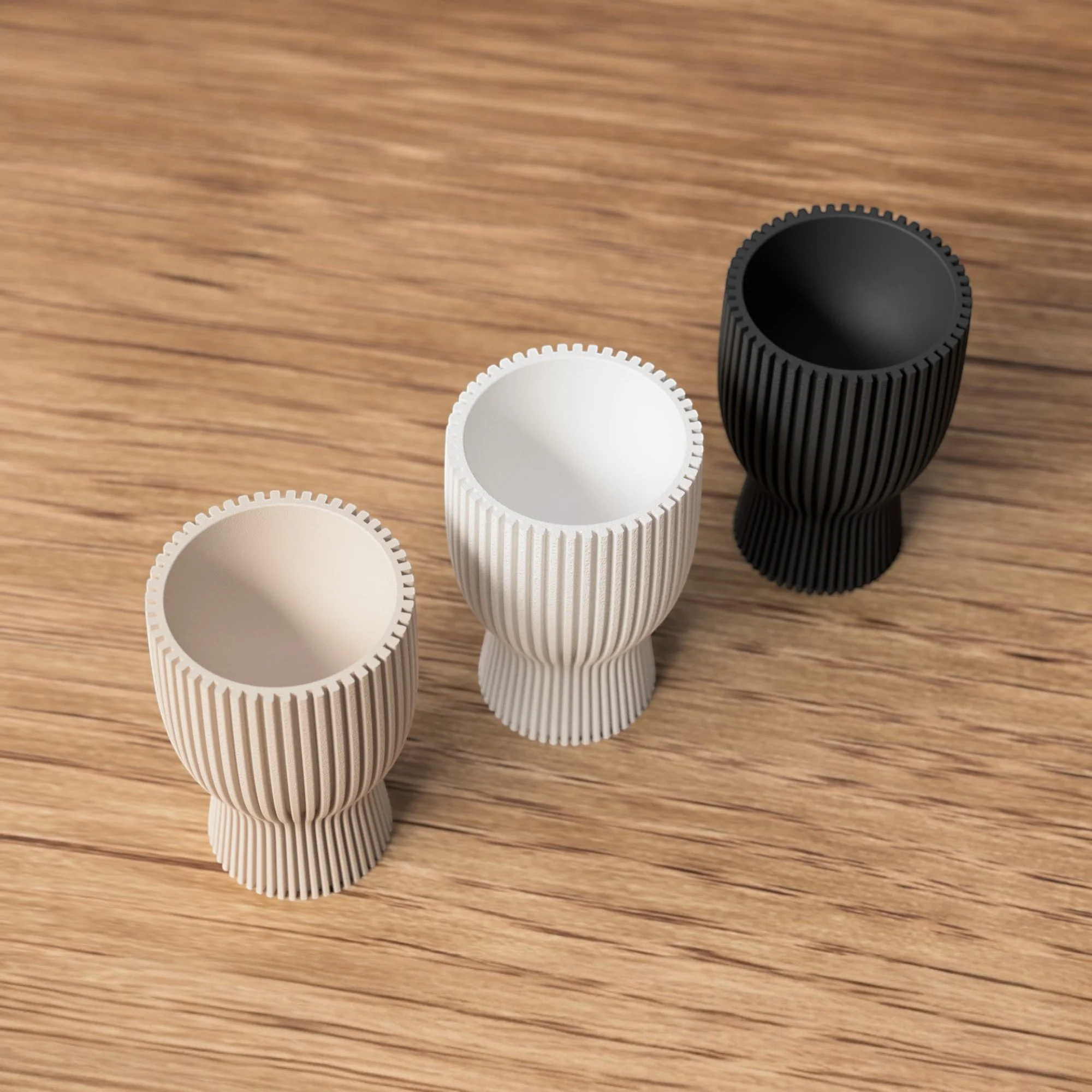 Drei wendbare Eierbecher auf Holzoberfläche, kombiniert in hellen und dunklen Farben als dekorative Eierhalter für Osterbrunch und Frühlingsdeko.