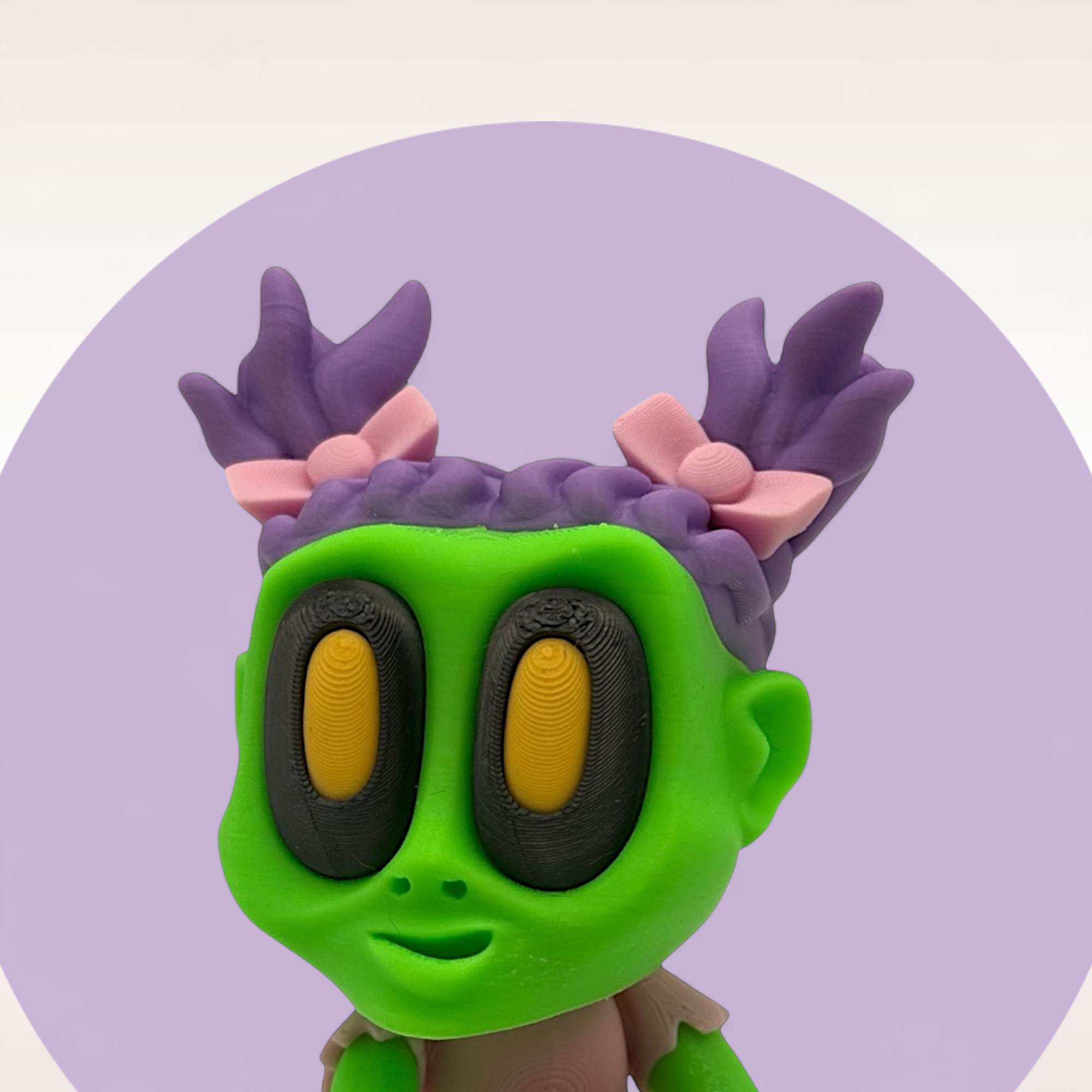 Gesichtsdetail einer grünen Zombiefigur mit großen Augen und lilafarbenen Haar-Details als auffällige Horror-Deko.