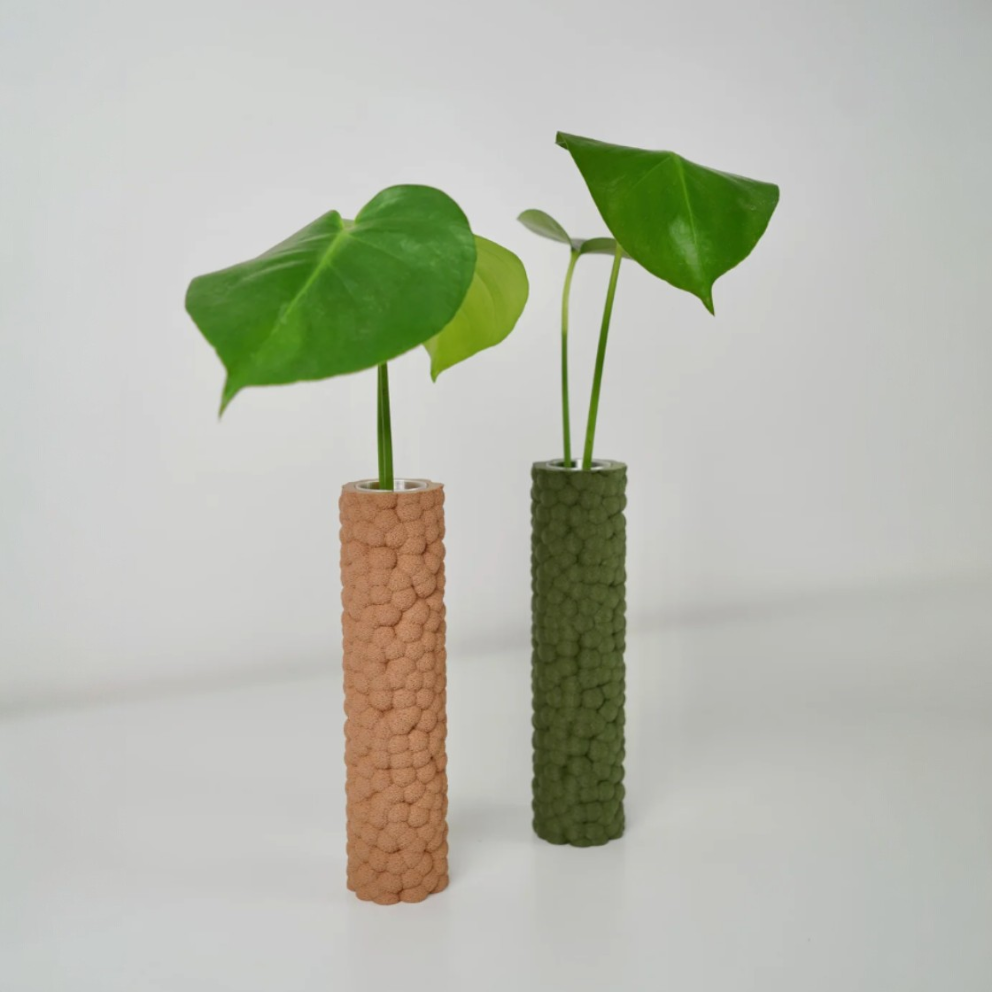 Brisa Dekovasen in Beige und Grün auf heller Fläche, dekoriert mit einzelnen Blättern als stilvolle Akzente für Regal oder Fensterbank.