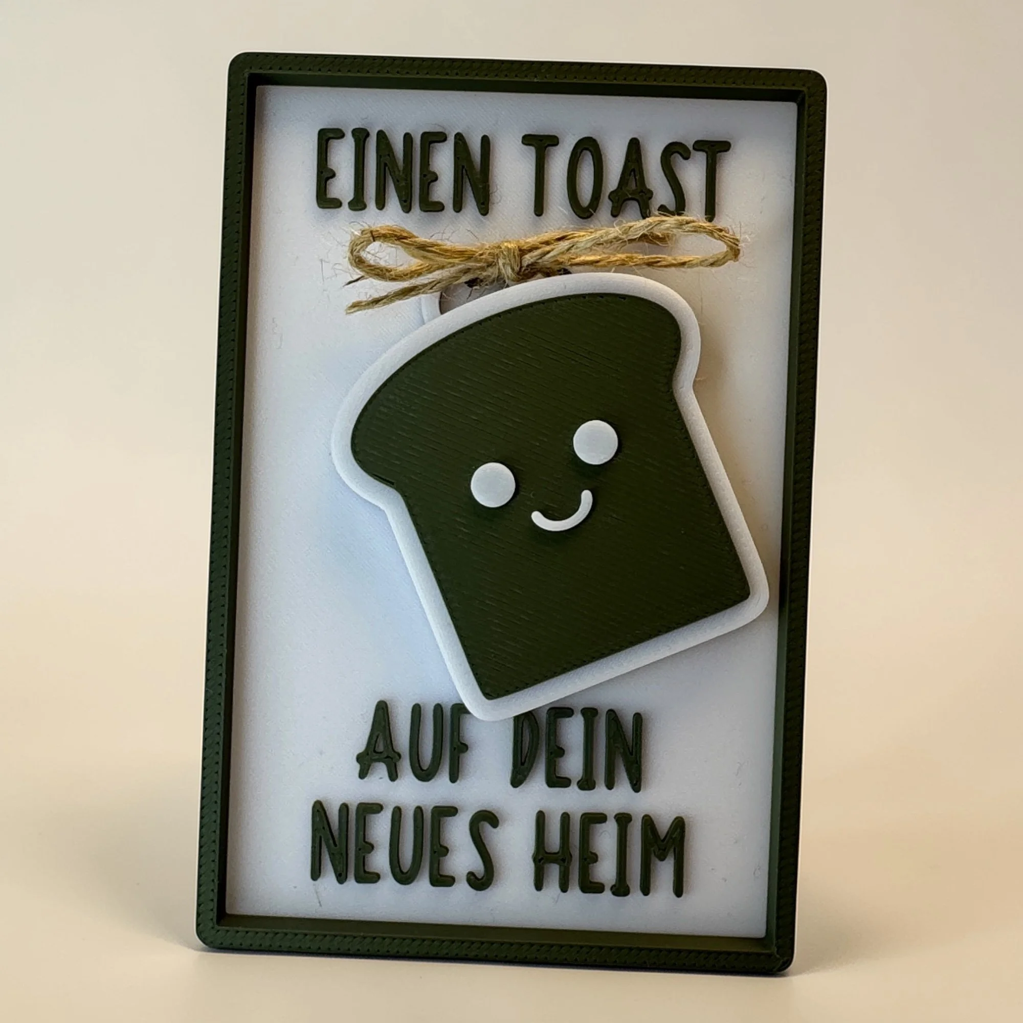 Karte zum neuen Zuhause mit abnehmbarem Toast-Schlüsselanhänger und Schriftzug Einen Toast auf dein neues Heim.