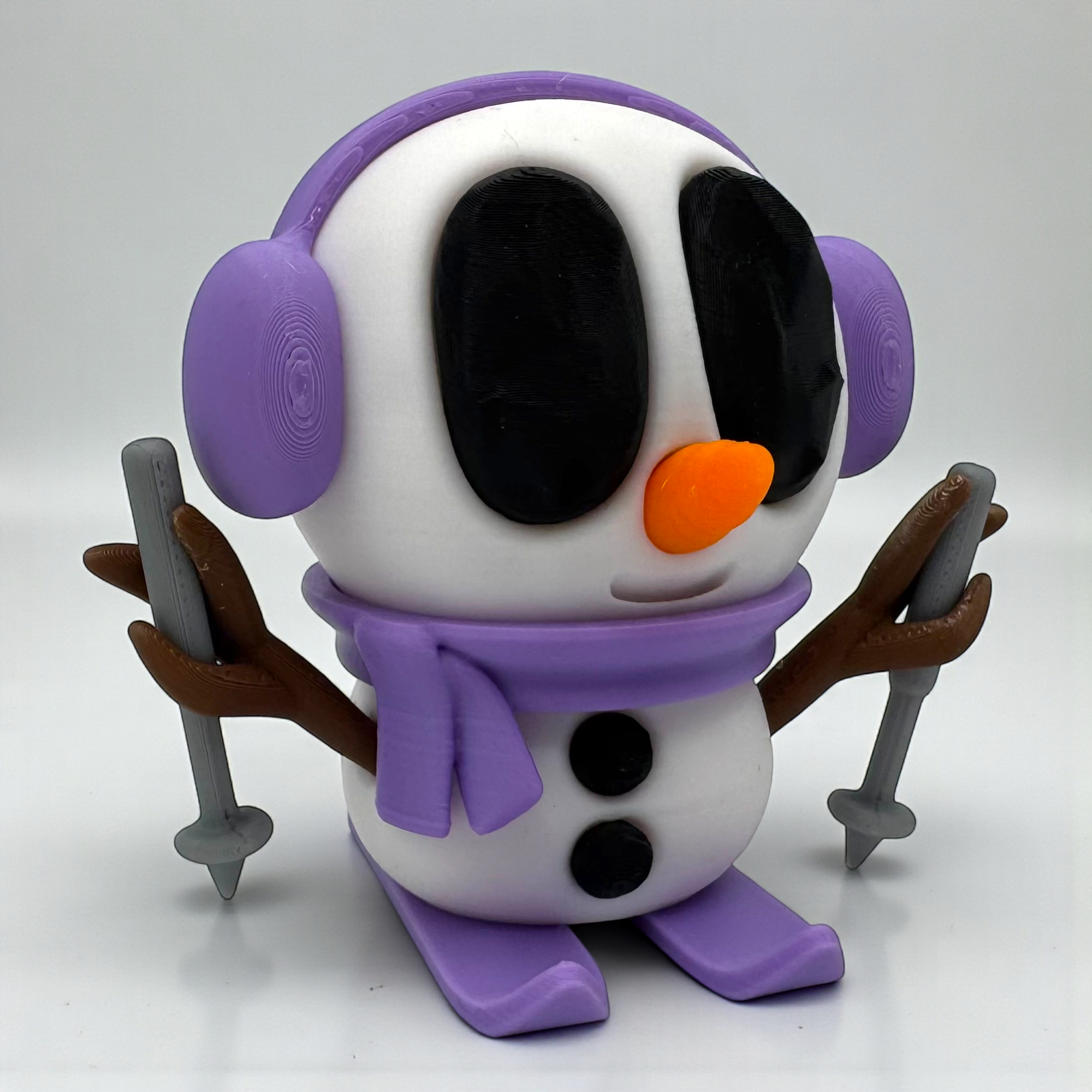 Violette Snowblobs Schneemannfigur mit Ohrenschützern und lilafarbenem Unterteil auf hellem Hintergrund, frontal und detailreich dargestellt.