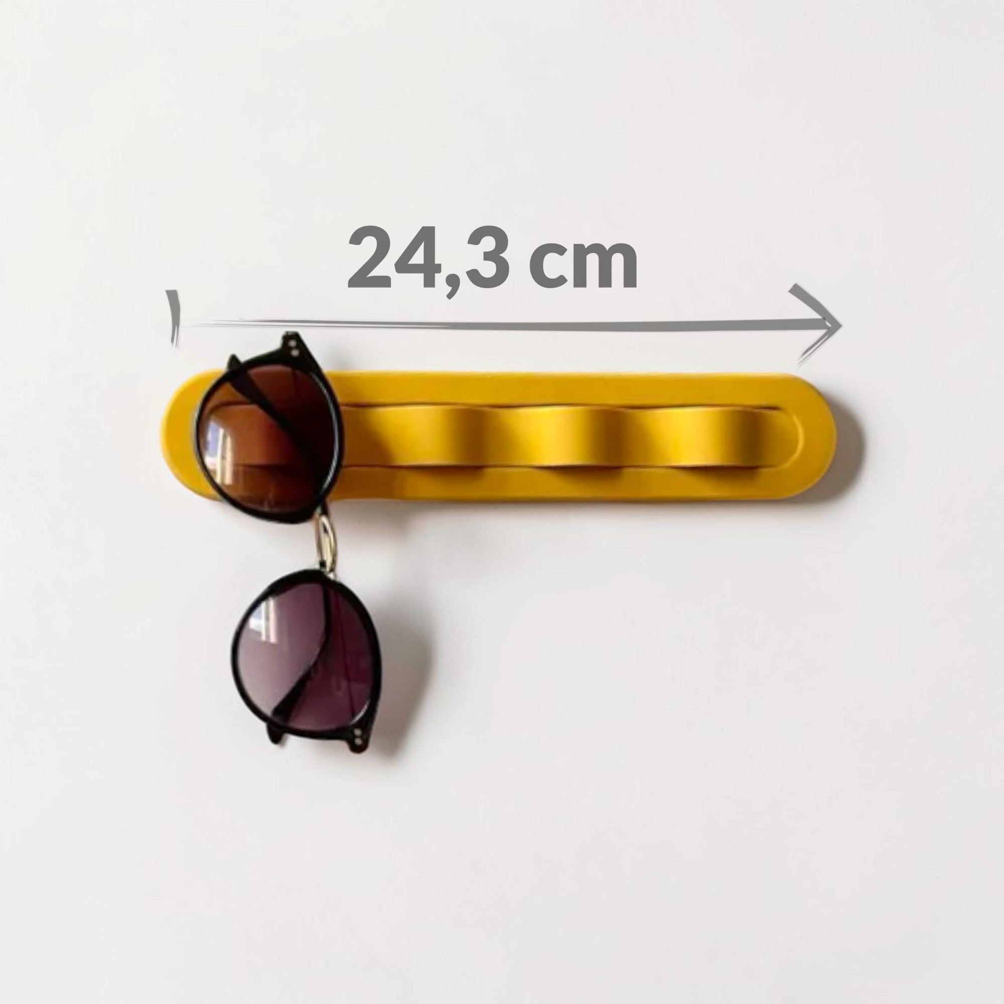 Sonnenbrillenhalter für die Wand mit bernsteinfarbener Front und heller Grundplatte, 24,3 cm lang, platzsparend für bis zu vier leichte Brillen.