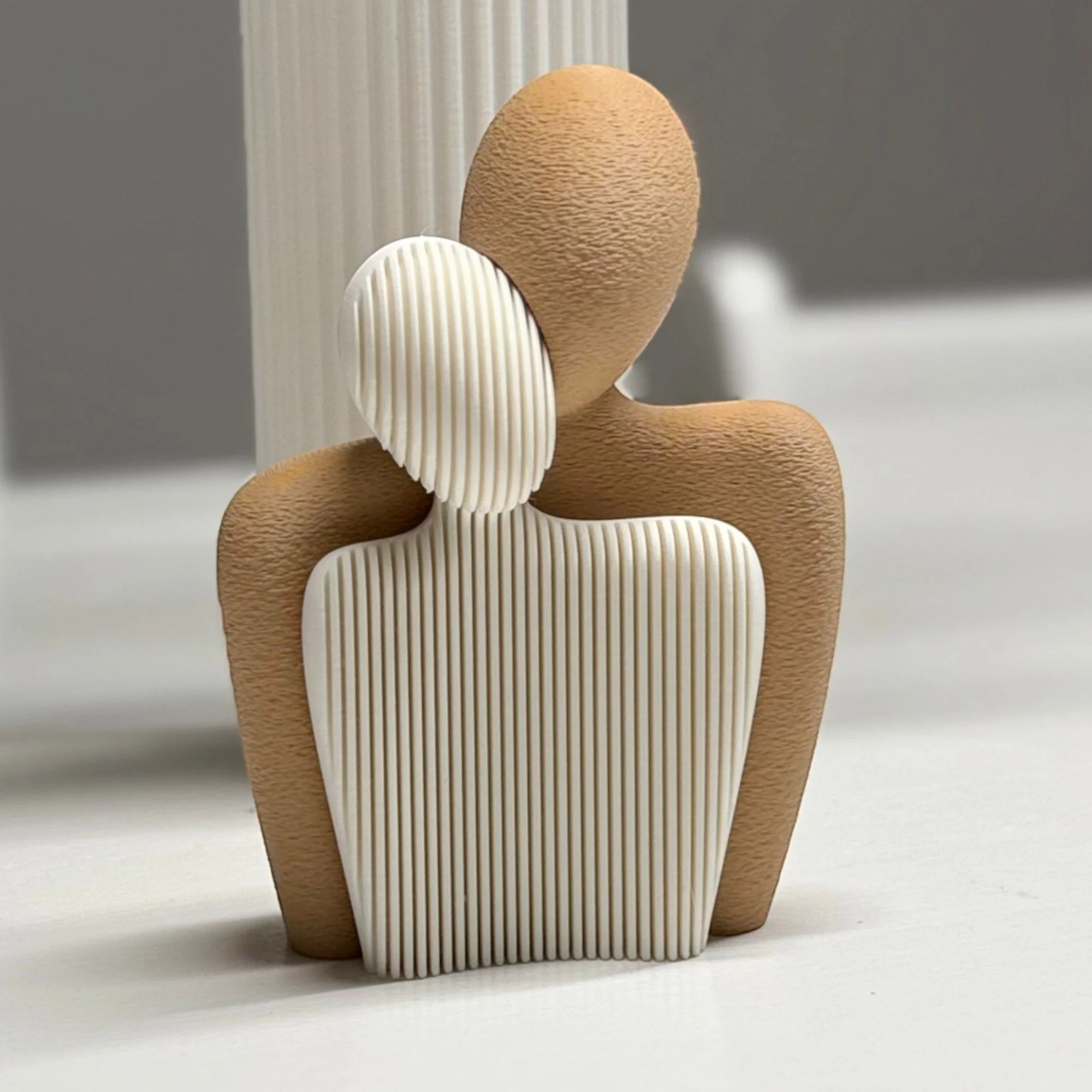 Zweiteilige Liebespaar Statue aus 3D-Druck, zusammengesetzt zu einer abstrakten Paarfigur mit geriffelter Oberfläche in Weiß und Holzoptik.