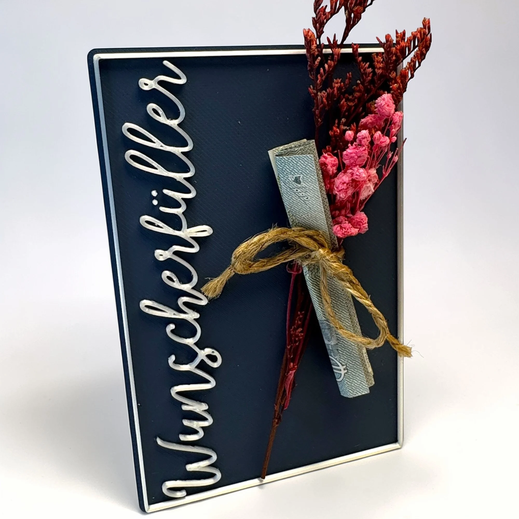 Freistehende Wunscherfüller Karte auf hellem Hintergrund mit weißer Kalligrafie, Schleife und floraler Dekoration für Geldgeschenk oder Gutschein