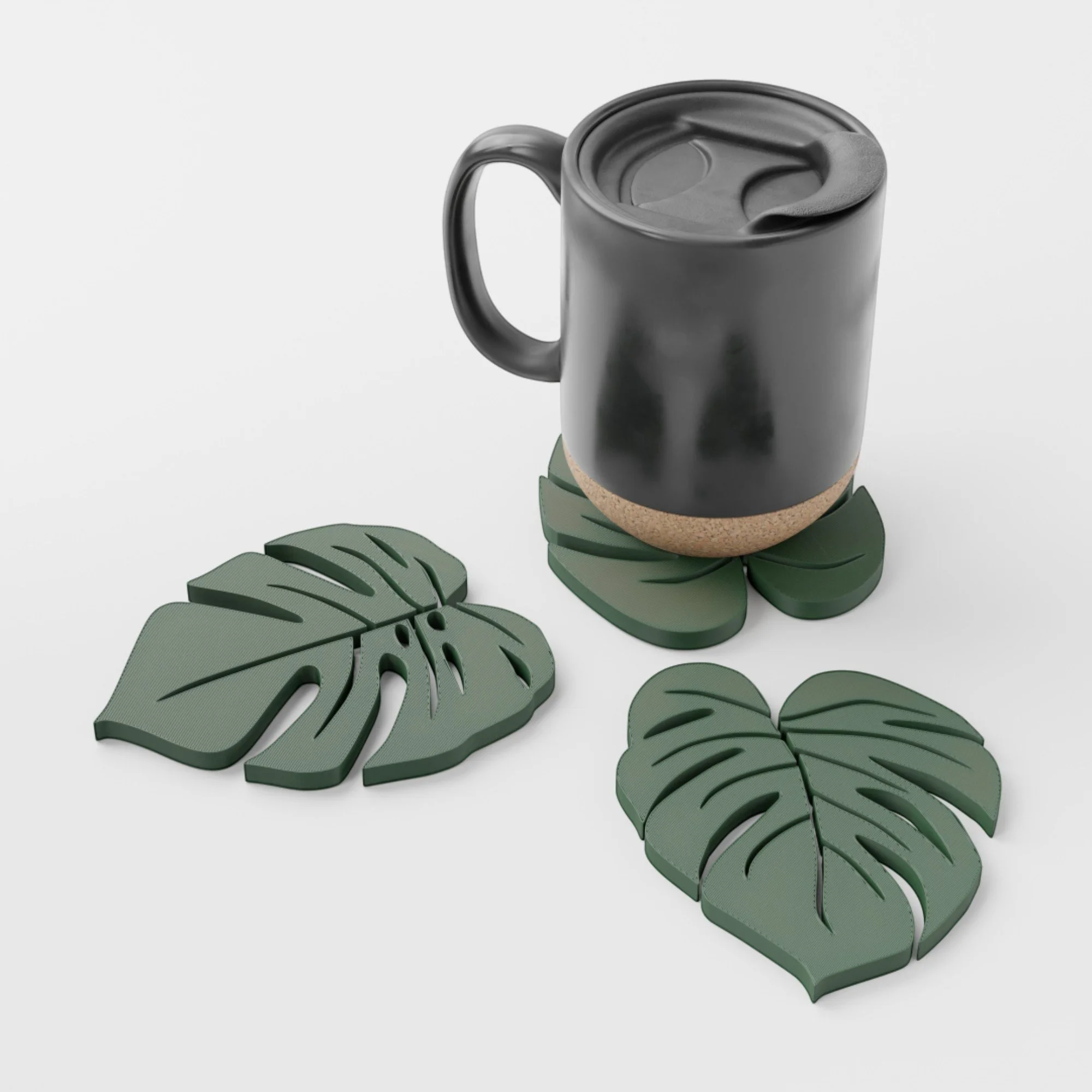 Monstera-Untersetzer-Komplett-Set mit schwarzer Tasse in Nutzung und drei grünen Blattdesigns als dekorativer Tischschutz