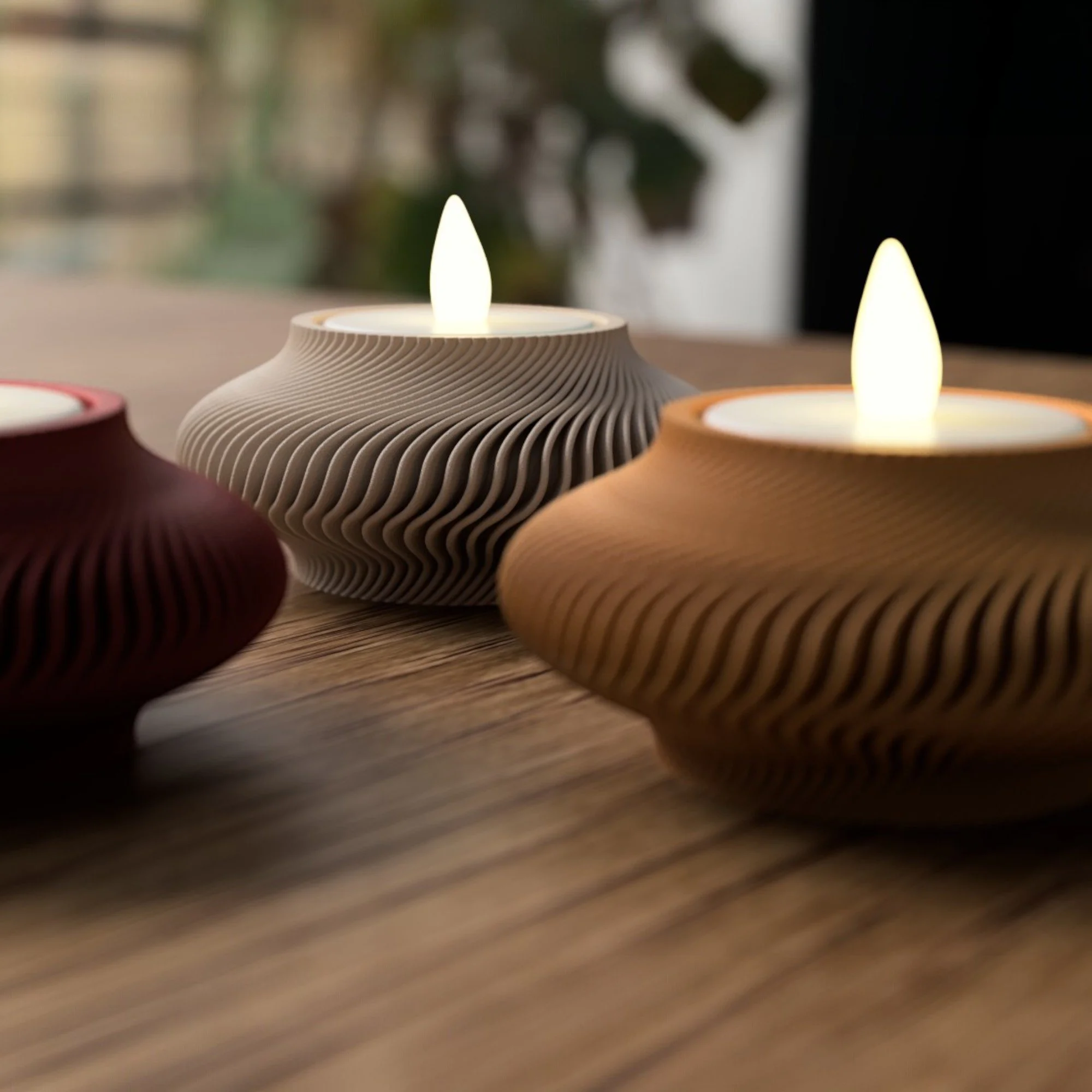 Leuchtende LED-Teelichthalter in Rot, Creme und Braun auf Holzfläche, seitlich aufgenommen als stilvoller Dekoakzent für Tisch oder Fensterbank.