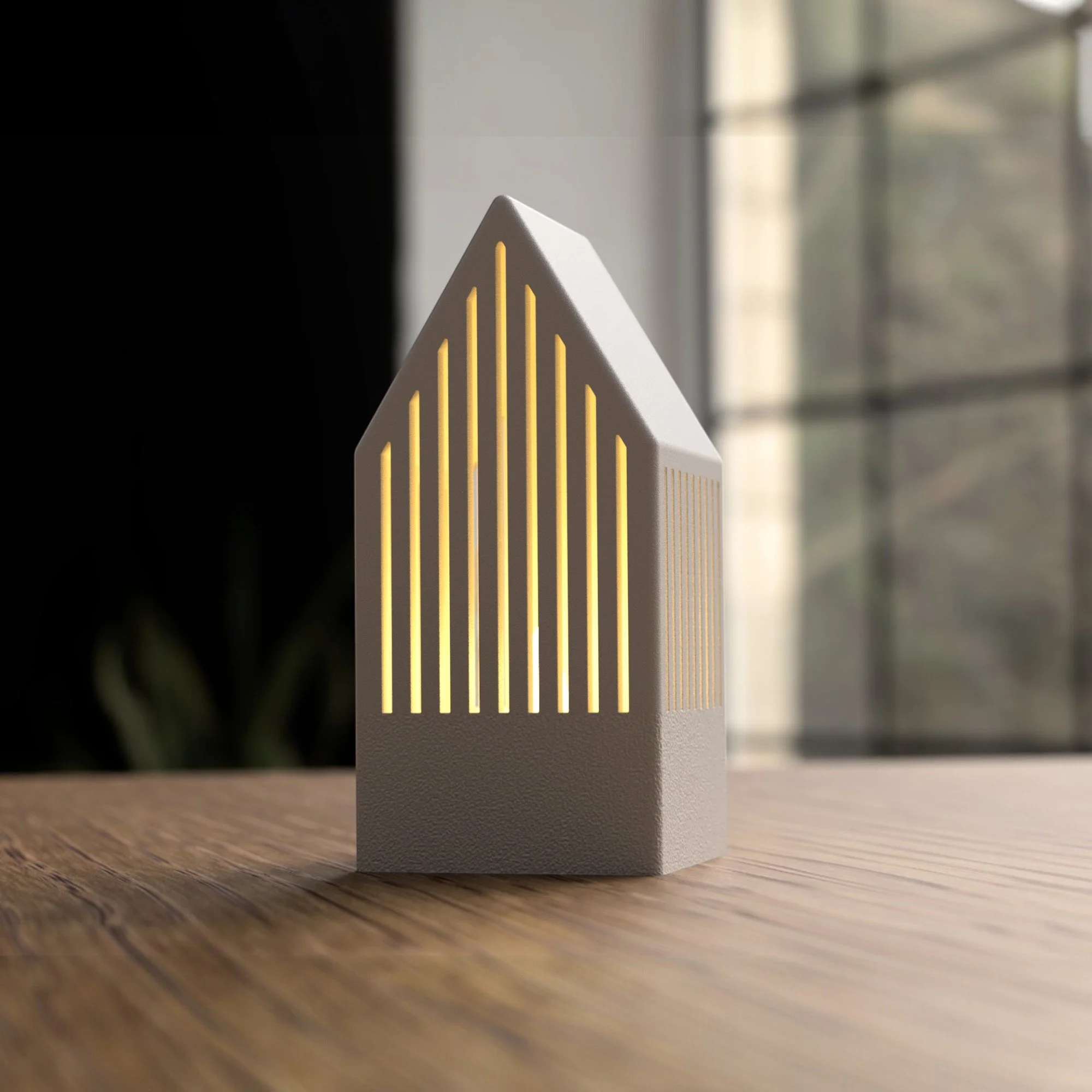 Graues Japandi Teelichthaus mit warmem Lichtschein durch feine Schlitzfenster, frontal inszeniert auf Holz für eine ruhige Wohnatmosphäre.