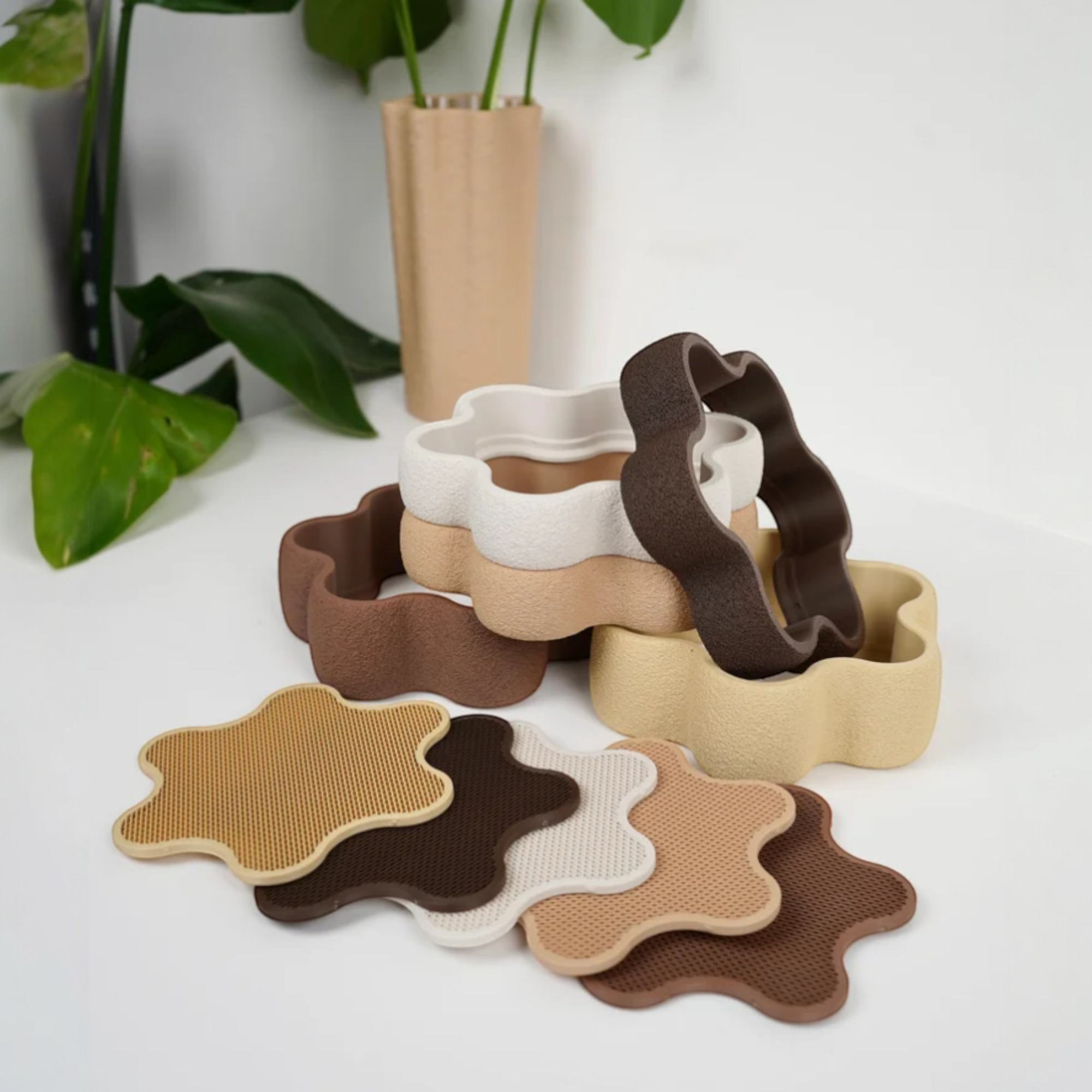 Schmuckschale in Blumenform in Beige und Braun mit passender Einlage und mehreren Einzelteilen dekorativ arrangiert auf hellem Untergrund.