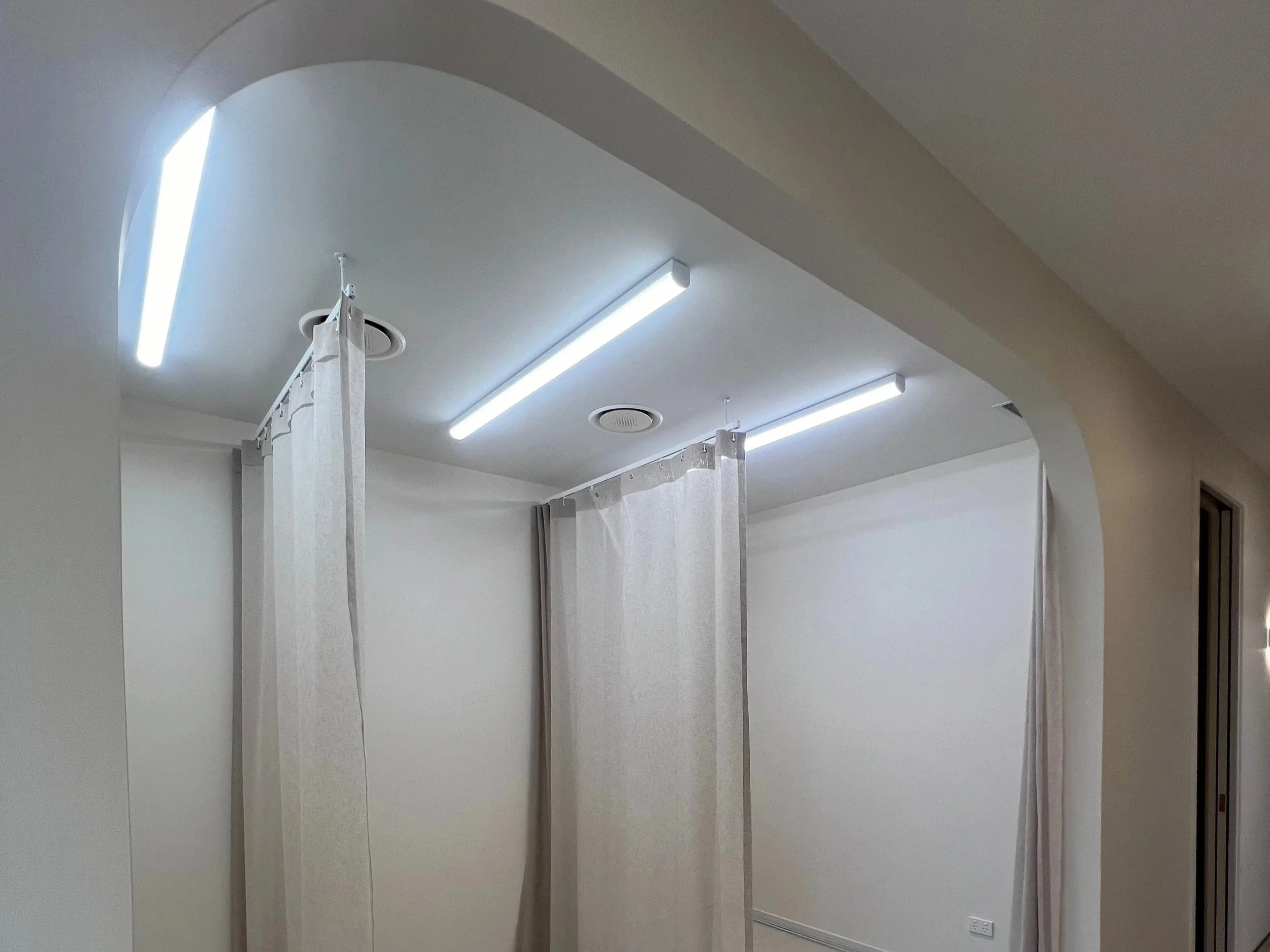 A curved arch into beauty rooms for Luxe Aesthetics adds a premium element to the commercial space.