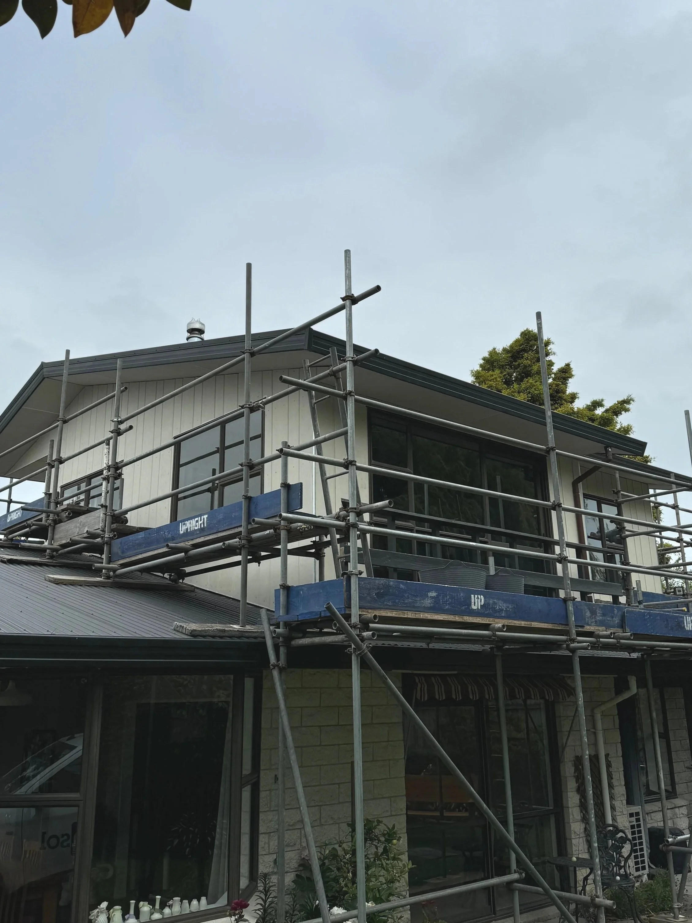 Scaffolding surrounds the top floor of a Lincoln home, with Dunshea Construction recladding the exterior walls of the home.