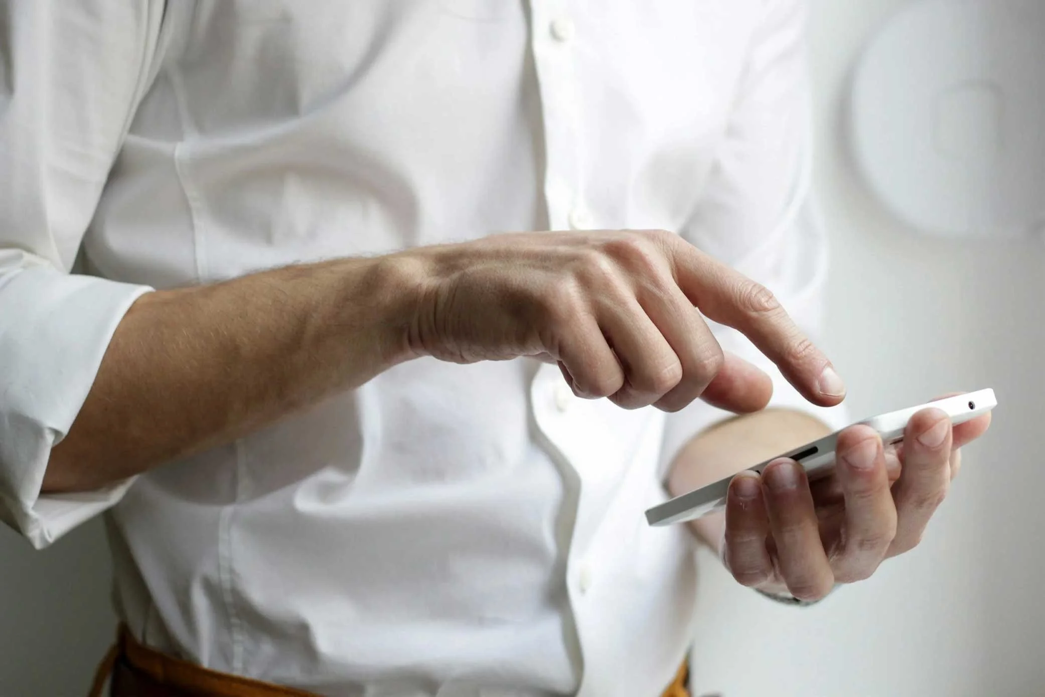 Person in white shirt using a smartphone.