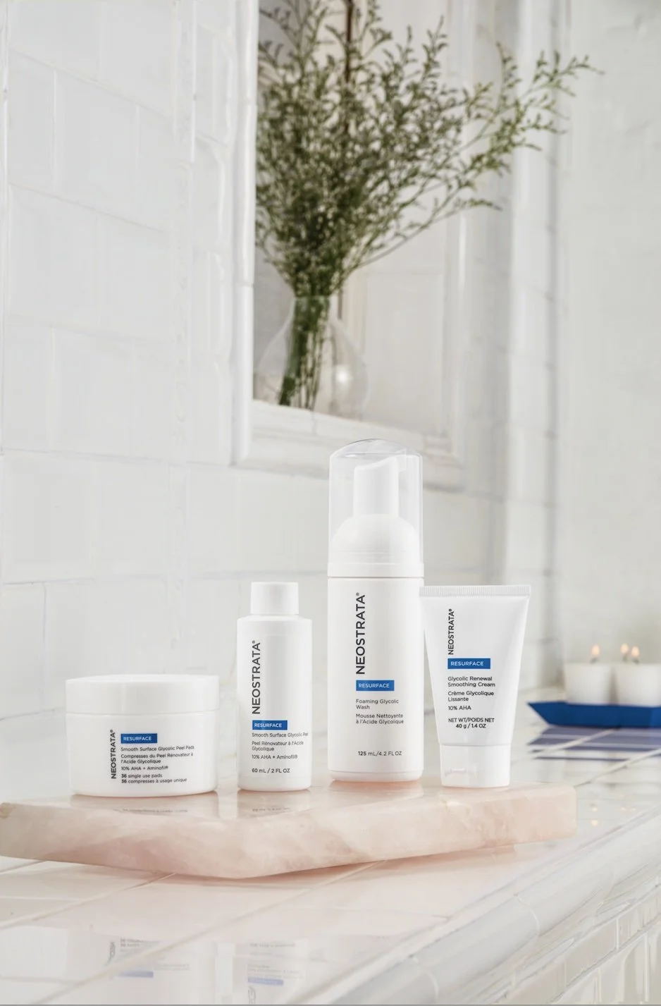 Skincare products from Neostrata with a white background and a flower in a vase in the background.