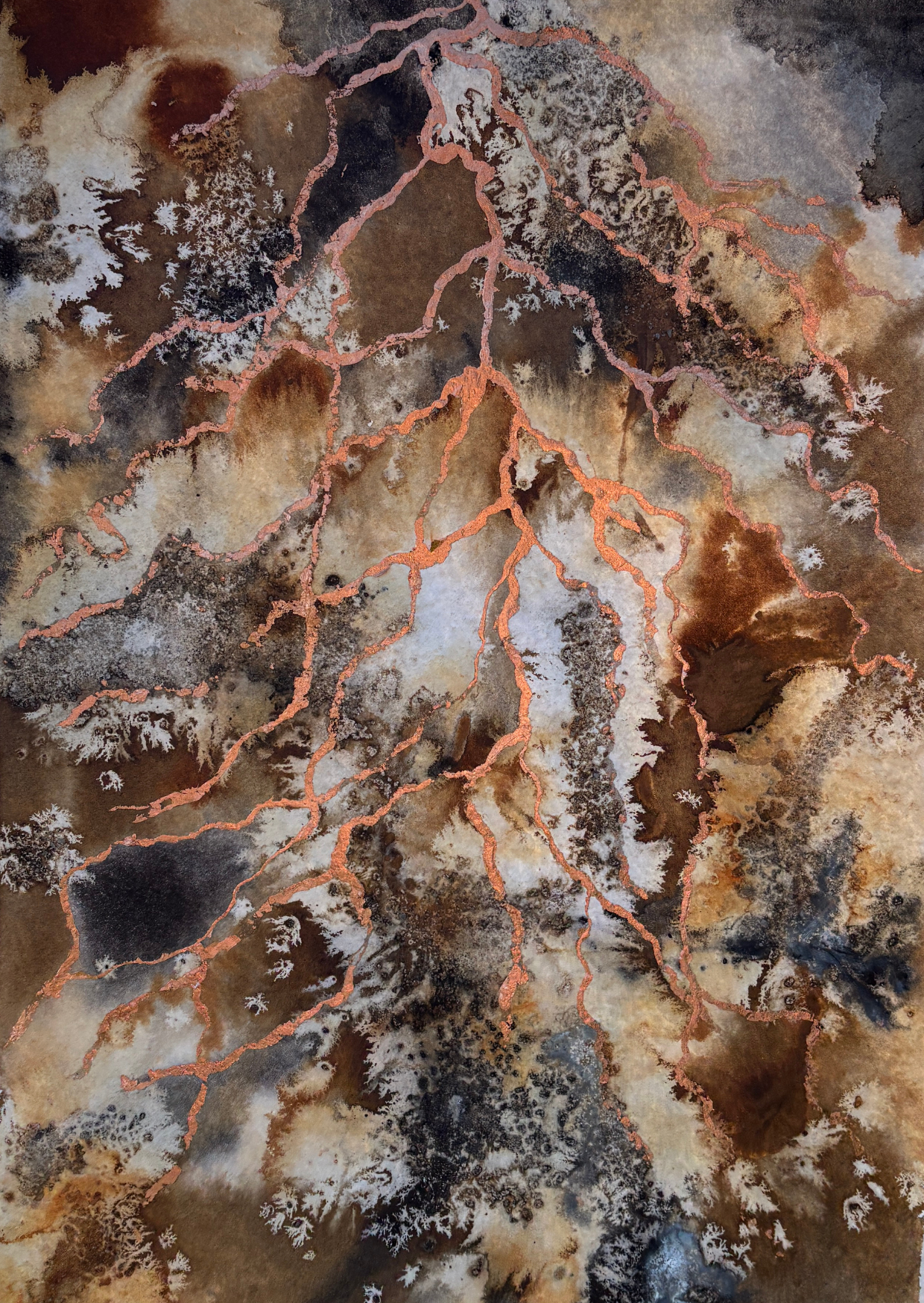 Earthy brown and muted black inks and pigments seep across the paper creating abstract patterns which evoke both soil and wider terrain, copper spreads down in root like strands from the top of the piece.