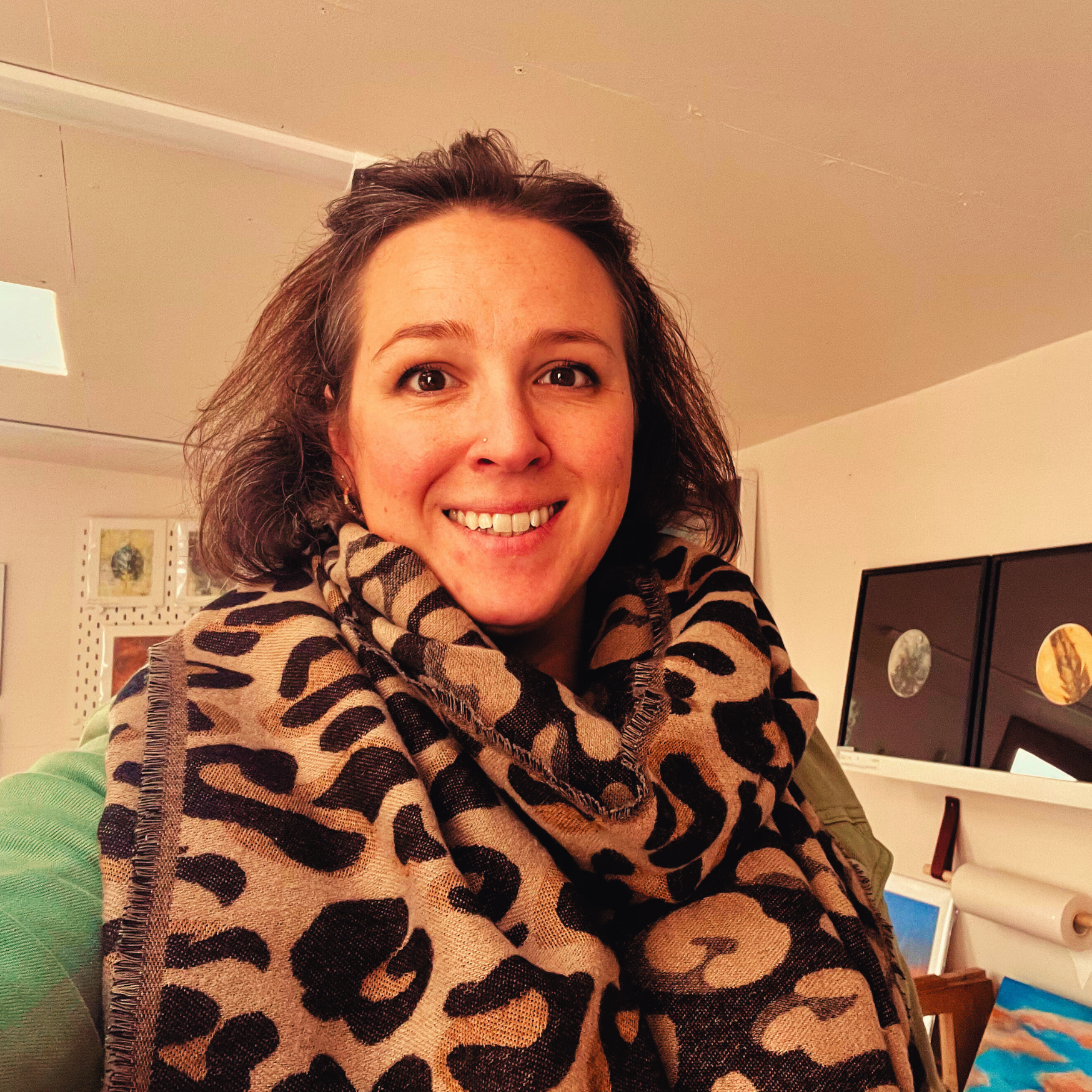 A picture of artist Kate Brown in her studio with artwork and in the background.