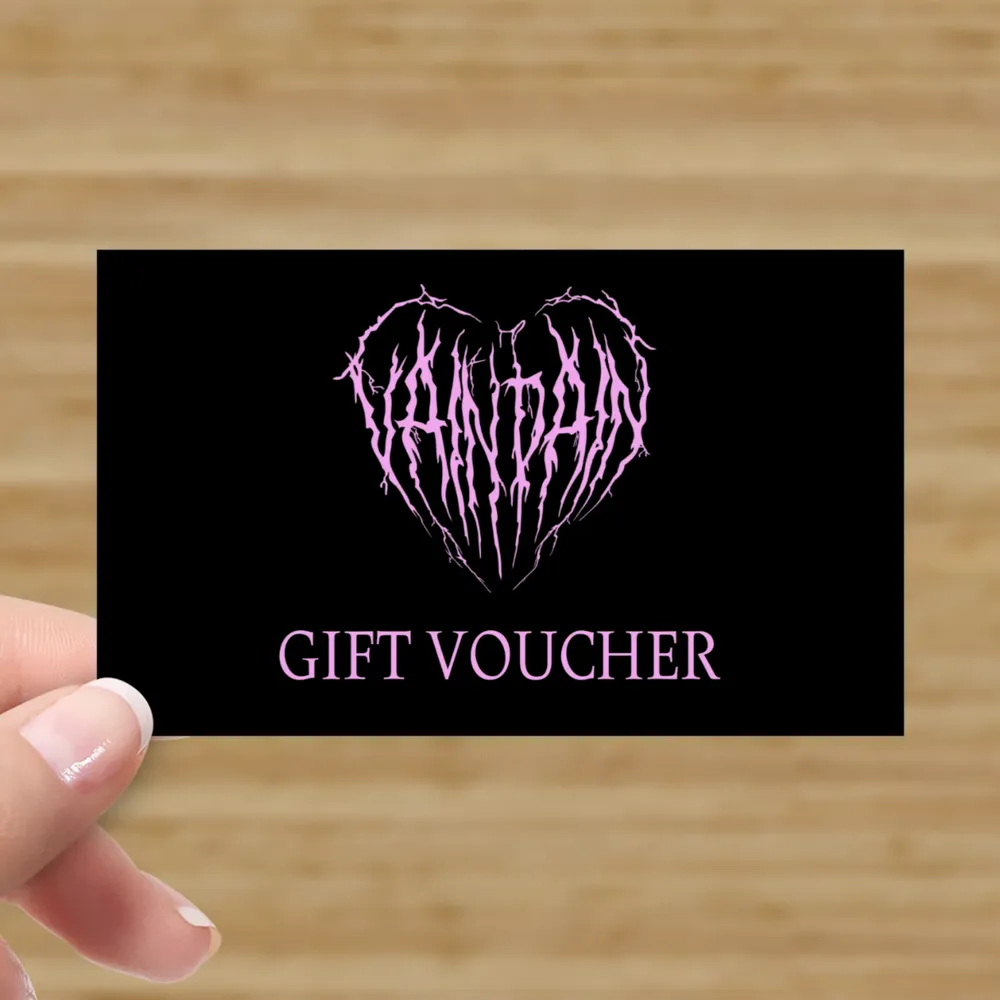 Black gift voucher with a purple heart made of thorny branches and the words "GIFT VOUCHER" in purple underneath.