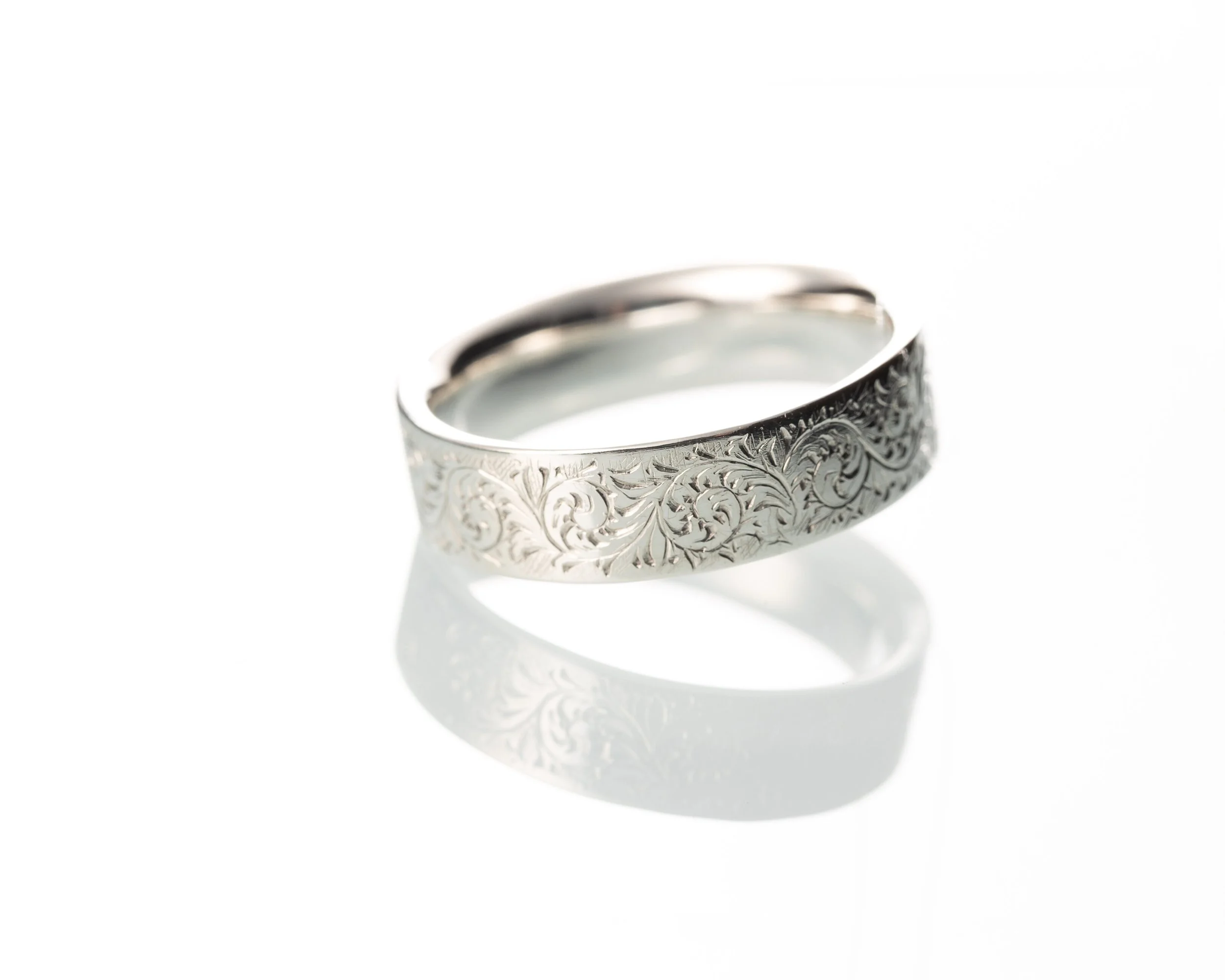 An engraved sterling silver wedding ring by silversmith Harry Stokes.