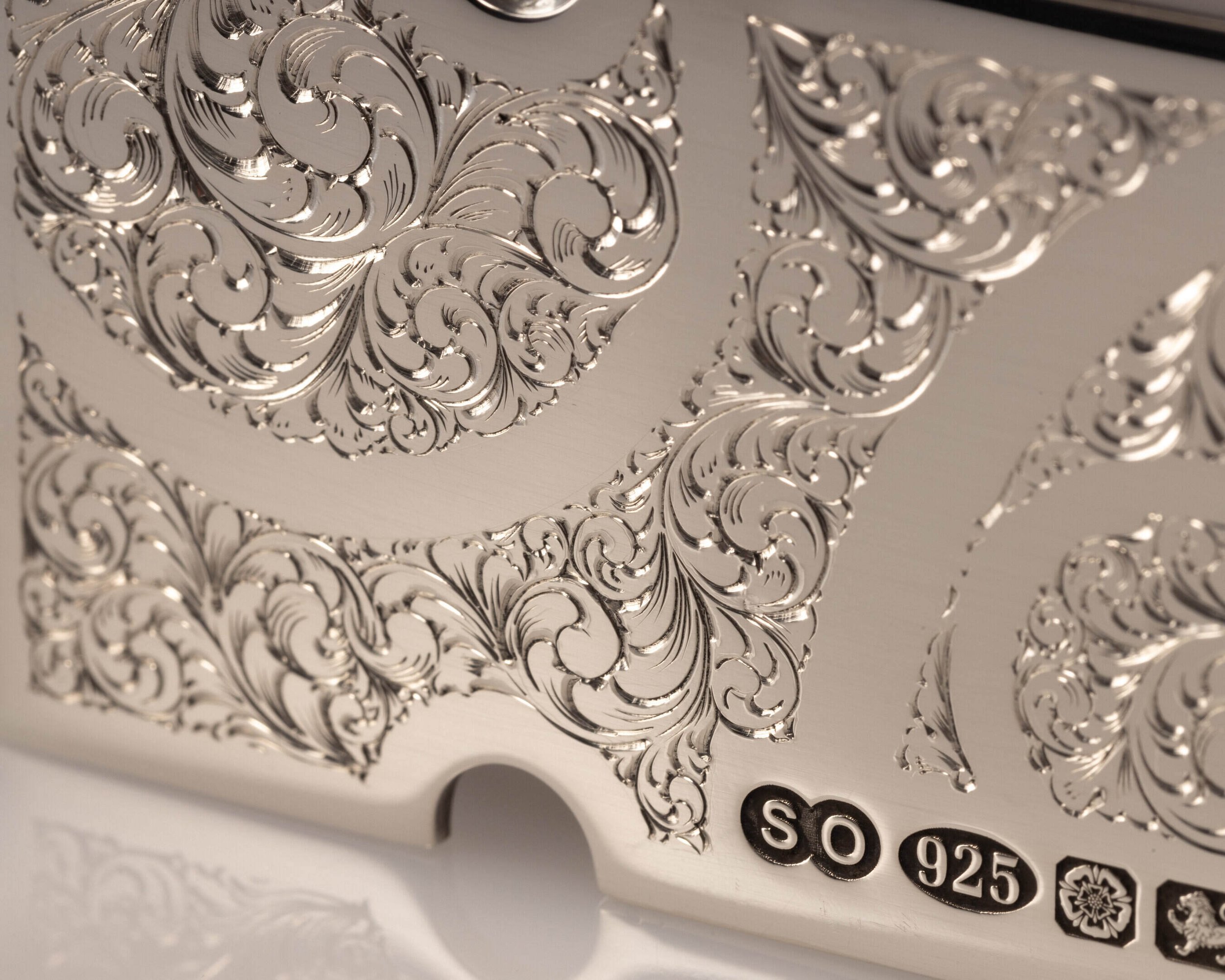 A sterling silver belt buckle with hallmark symbols and engraved filigree design by silversmith Harry Stokes.