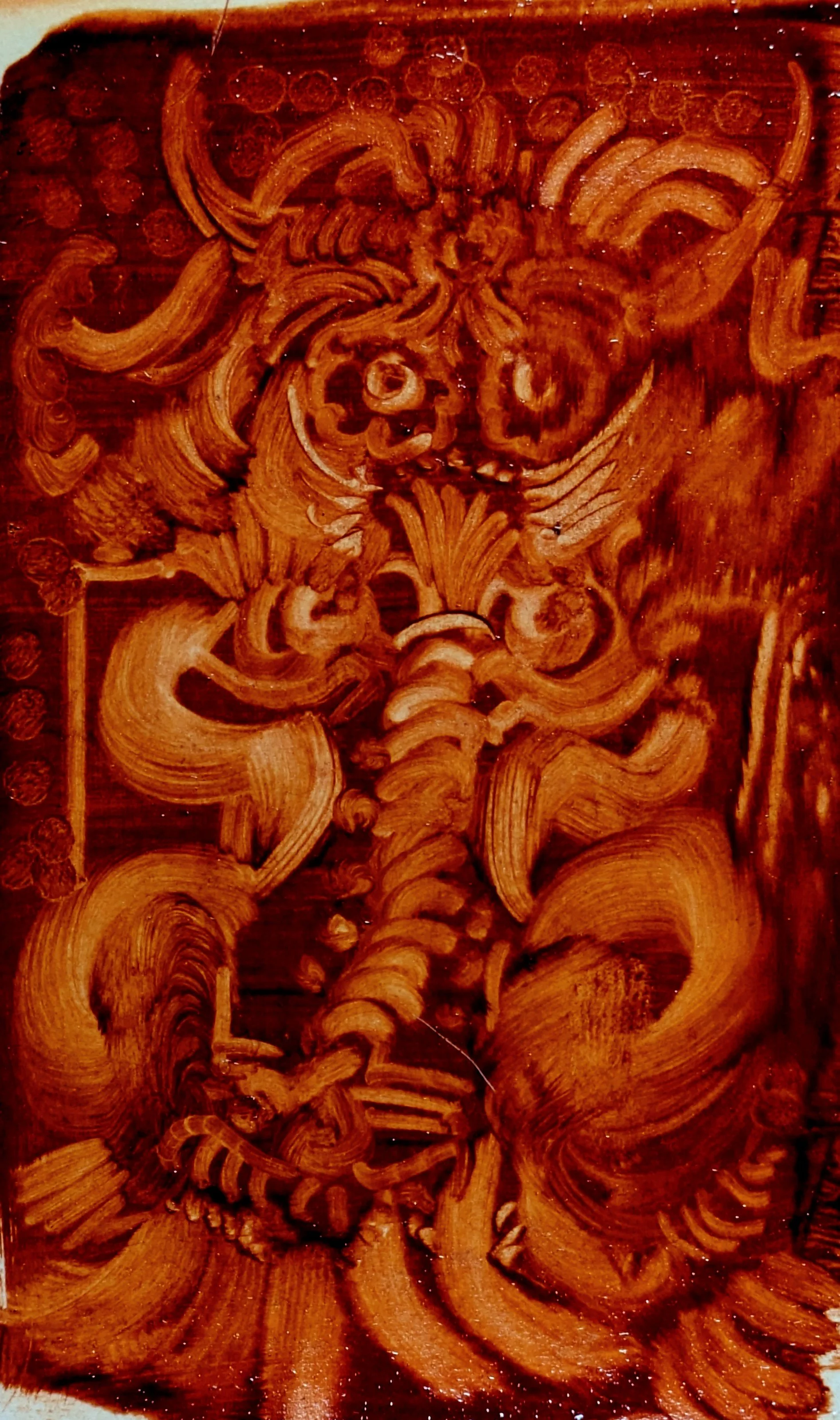 Intricate wood engraving of a humanoid face with exaggerated features, surrounded by decorative swirling patterns.