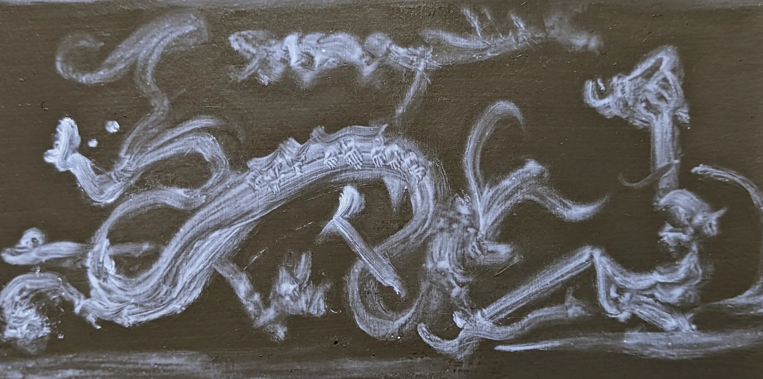 White chalk markings on a dark surface, appearing as abstract swirls and lines.