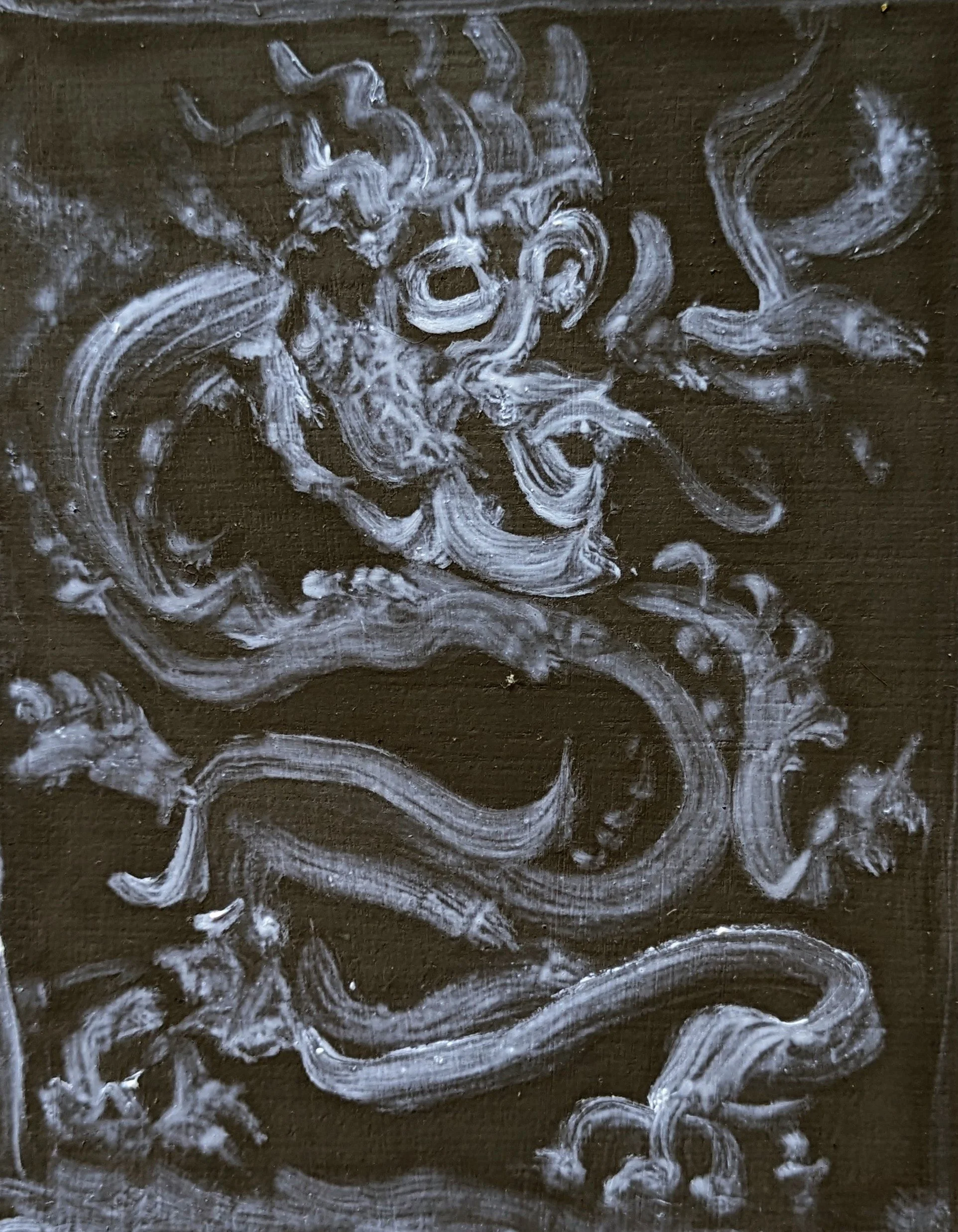 White chalk or paint on a dark surface creating abstract swirling and looping patterns.