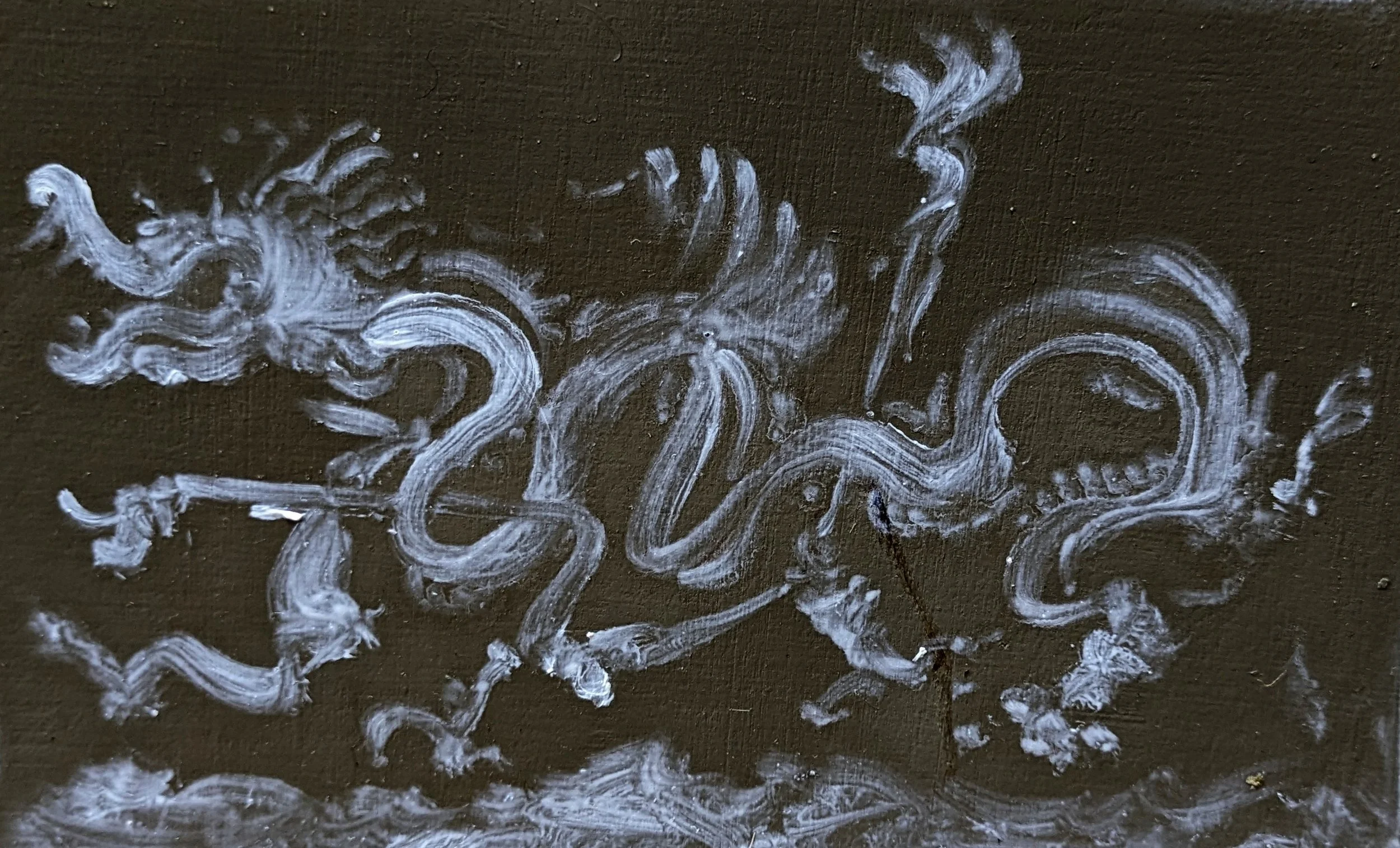 White chalk or paint lines and swirls on a dark surface, possibly a chalkboard or blackboard.