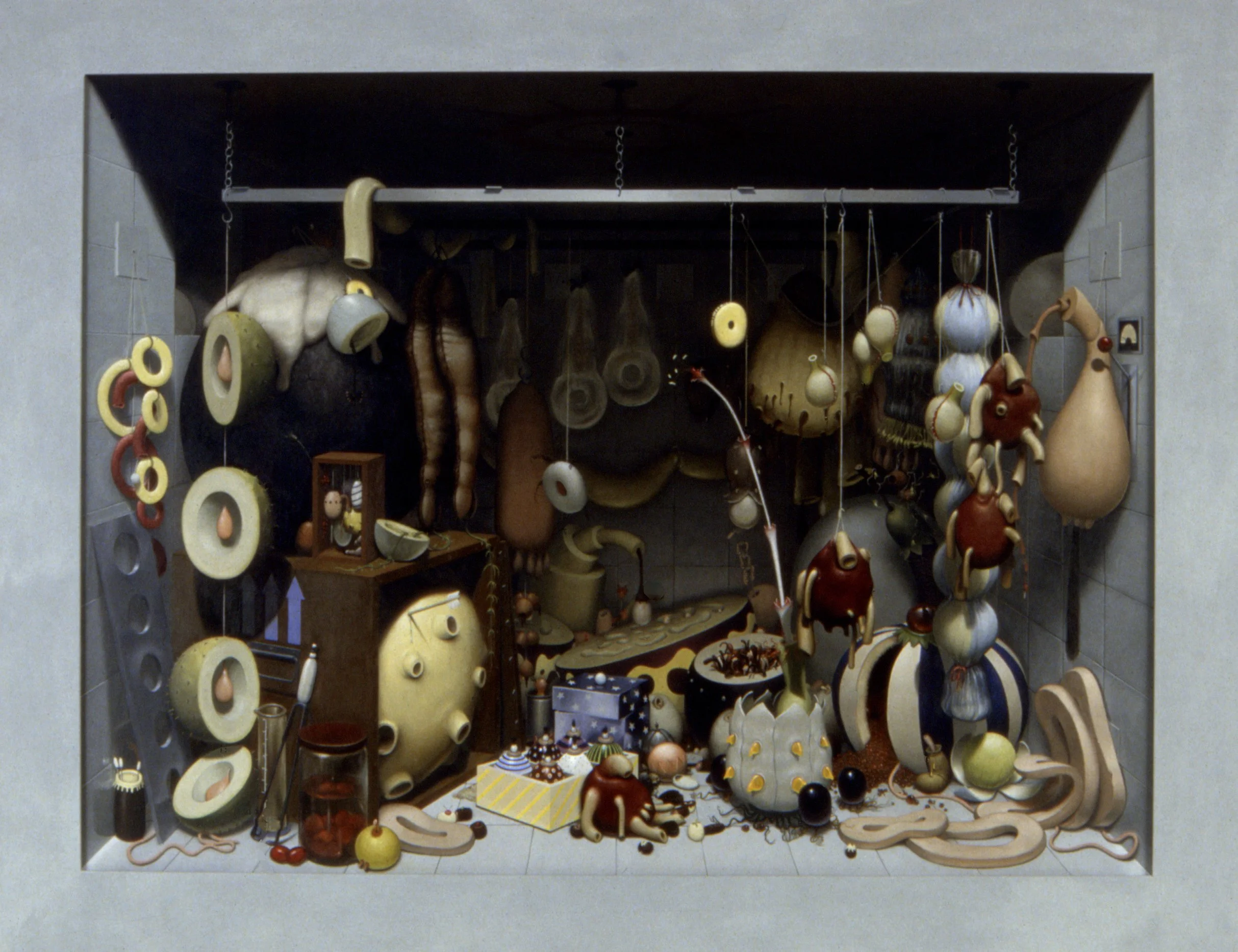 A display of various ceramic and wooden objects, including sculptures, bowls, and hanging ornaments, arranged on shelves and the floor within a recessed wall space.