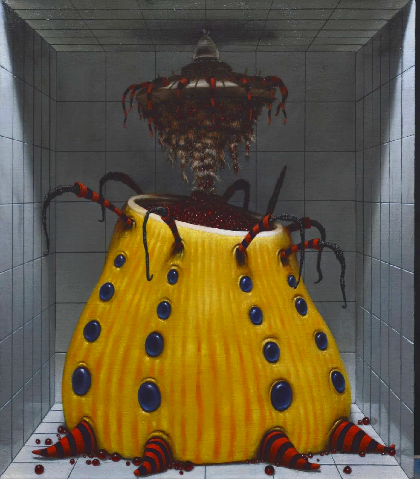 A large, yellow, stylized insect sculpture with blue spots and striped legs, placed inside a tiled display case. The insect appears to have a metallic head and is surrounded by red beads or balls.