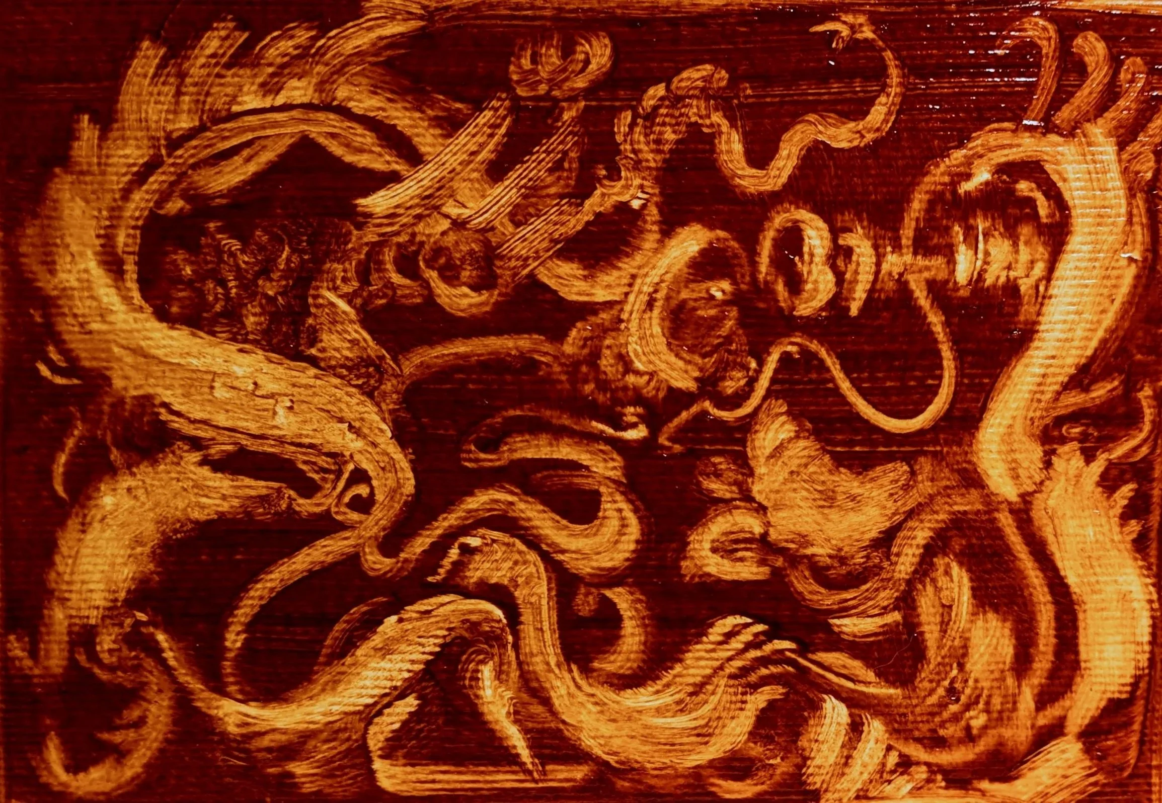 A close-up image of a wooden surface with intricate swirling carvings or patterns.