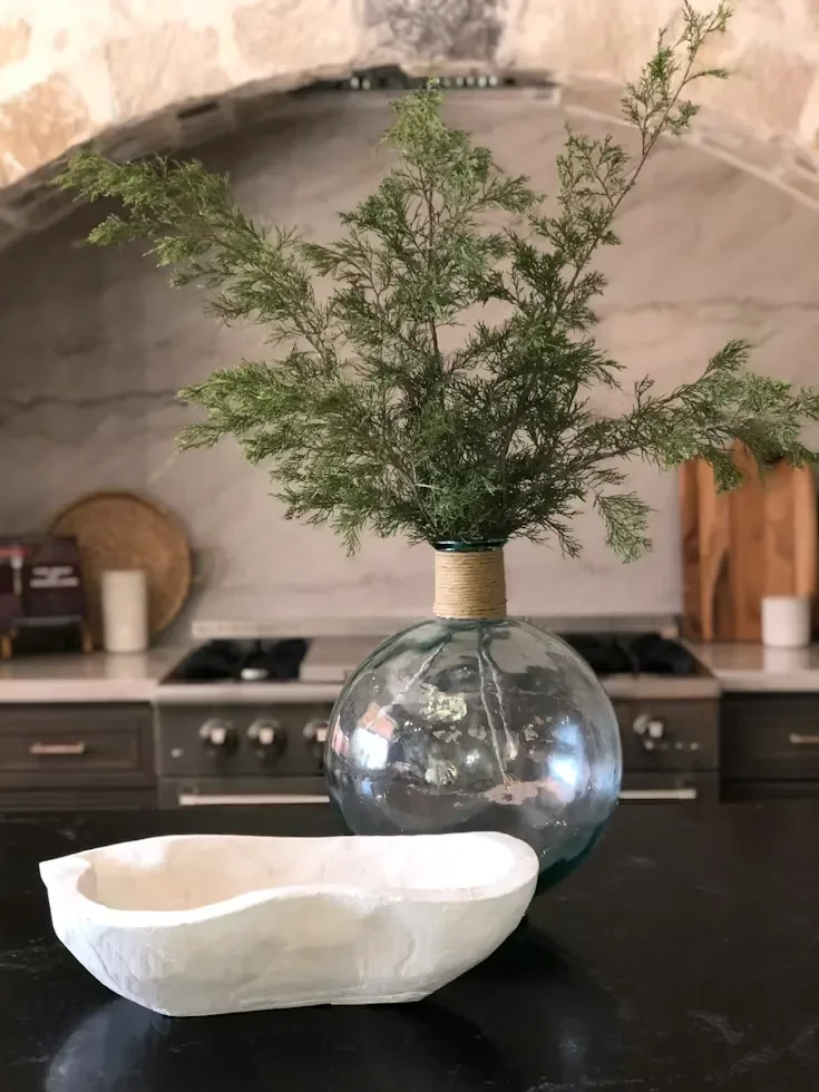 Kitchen stove under an arch with fresh flowers on an island